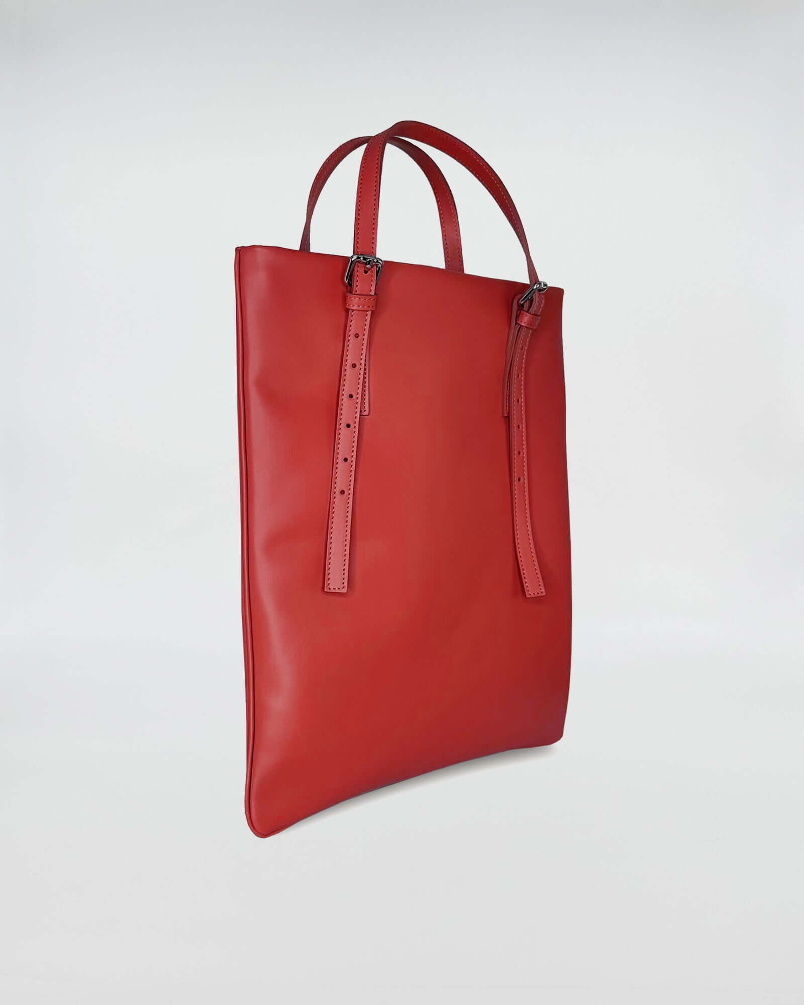 AMELIE PORTACOMPUTER red leather bag with sleek design and adjustable straps.