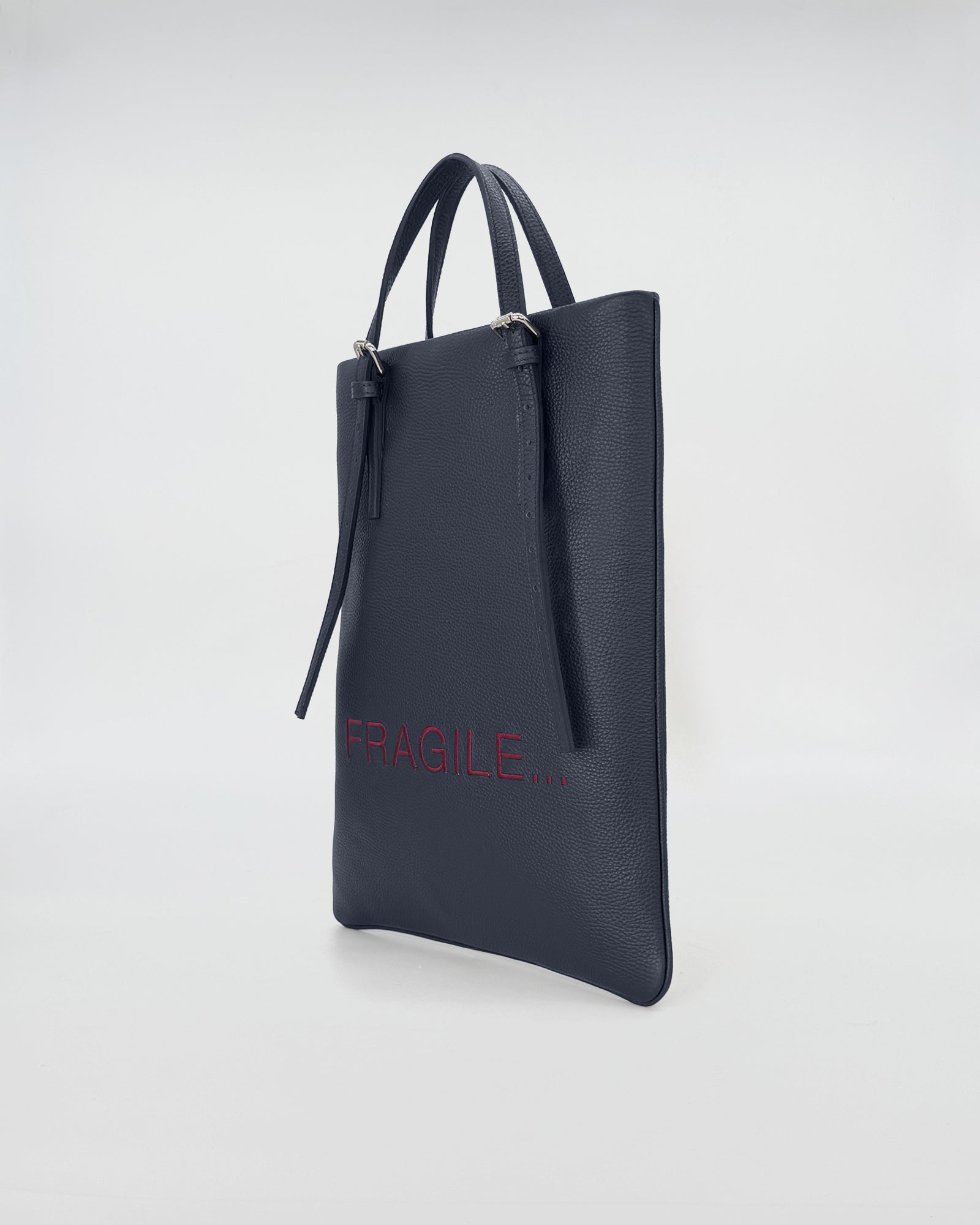 Elegant navy leather tote bag with 'FRAGILE' text, designed for contemporary work style and versatility.