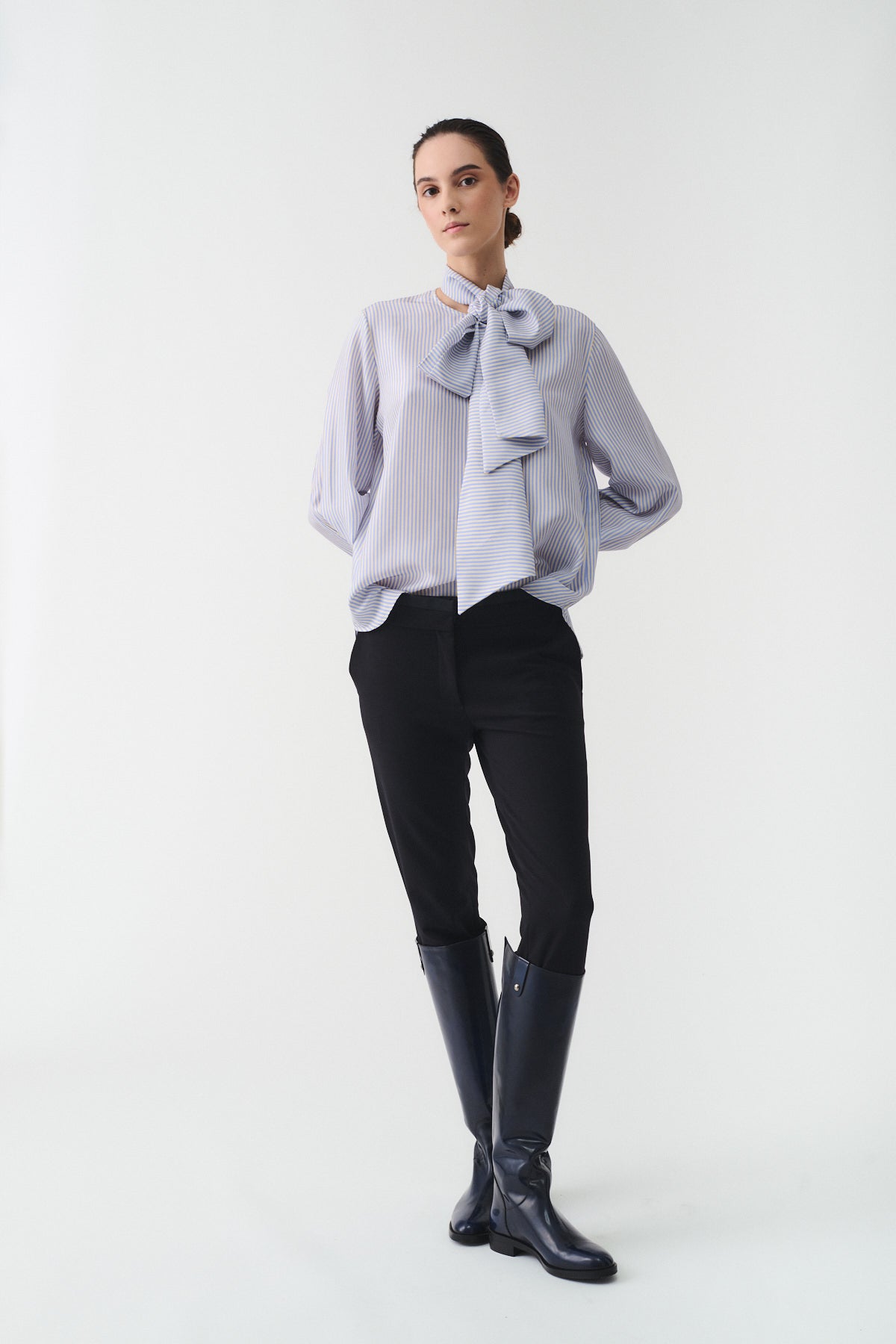 CAMICIA CHARLOTTE IN SETA CON SCIARPA indossata da una modella con pantaloni neri e stivali alti, look elegante.