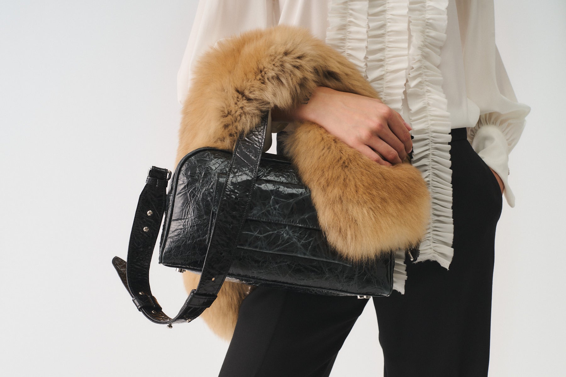 Zoe Small Vitello Strizzato bag with fur detail, worn elegantly in a fashion setting.