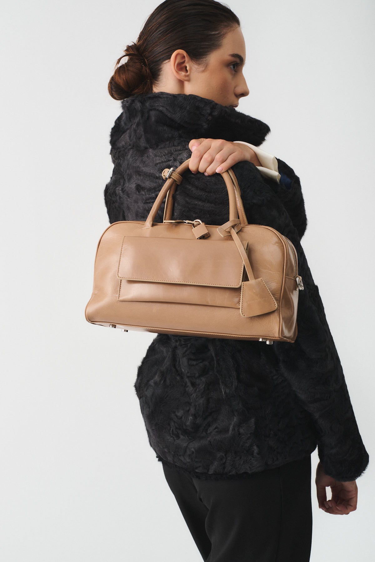 Model holding the ZOE SMALL VITELLO SEMILUCIDO bag, showcasing its stylish design and versatility.