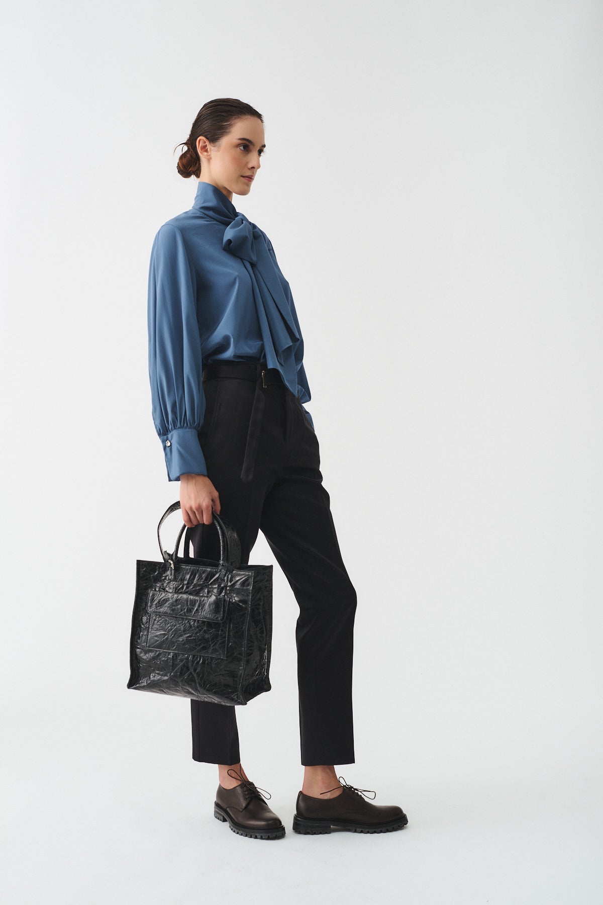 CAMICIA CHARLOTTE IN SETA CON SCIARPA indossata da donna in elegante outfit con borsa nera.