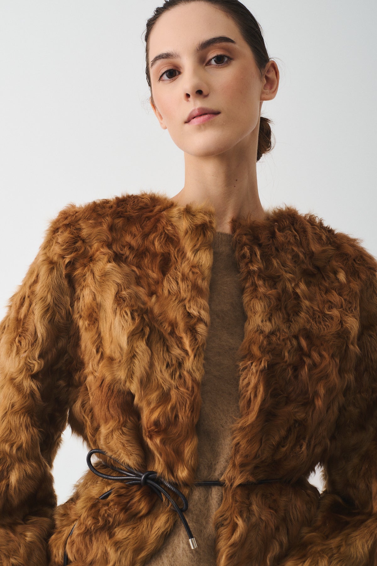 Elegant caban in upcycled lamb with bold volume, featuring a detachable wool vest for versatile styling.