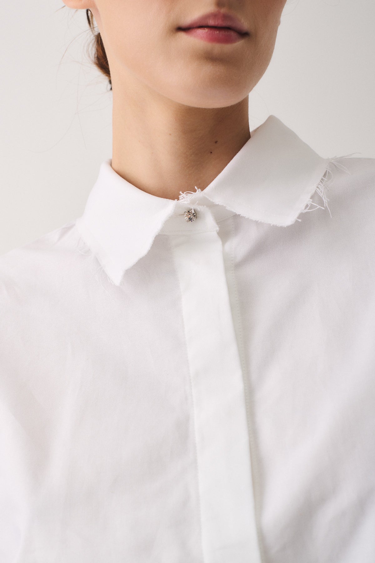 Dettaglio del colletto sfrangiato della CAMICIA COTONE OXFORD, con bottoni gioiello per un look raffinato.