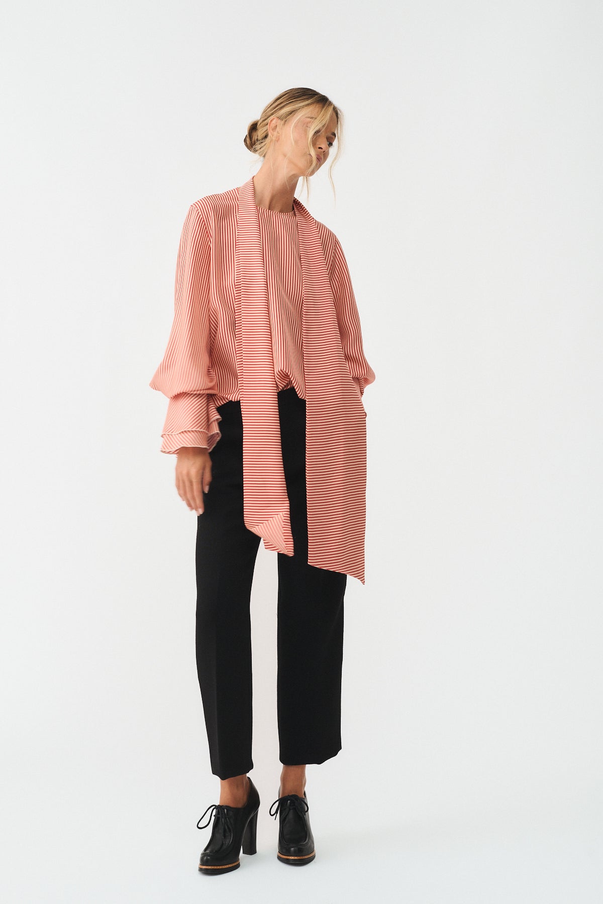 CAMICIA CHARLOTTE IN SETA CON SCIARPA indossata da una donna con pantaloni neri e scarpe eleganti.