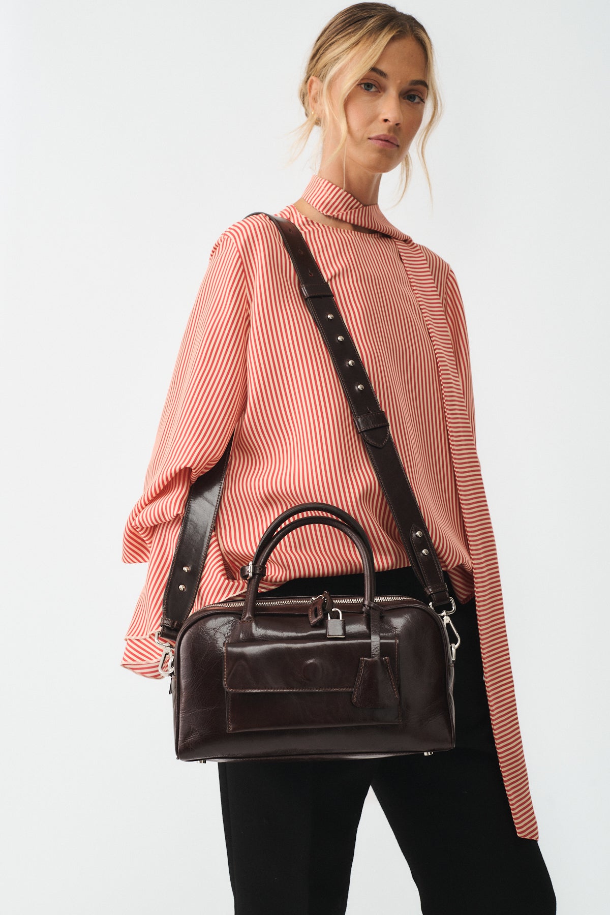 Model showcasing ZOE SMALL VITELLO SEMILUCIDO handbag with a stylish red striped blouse.