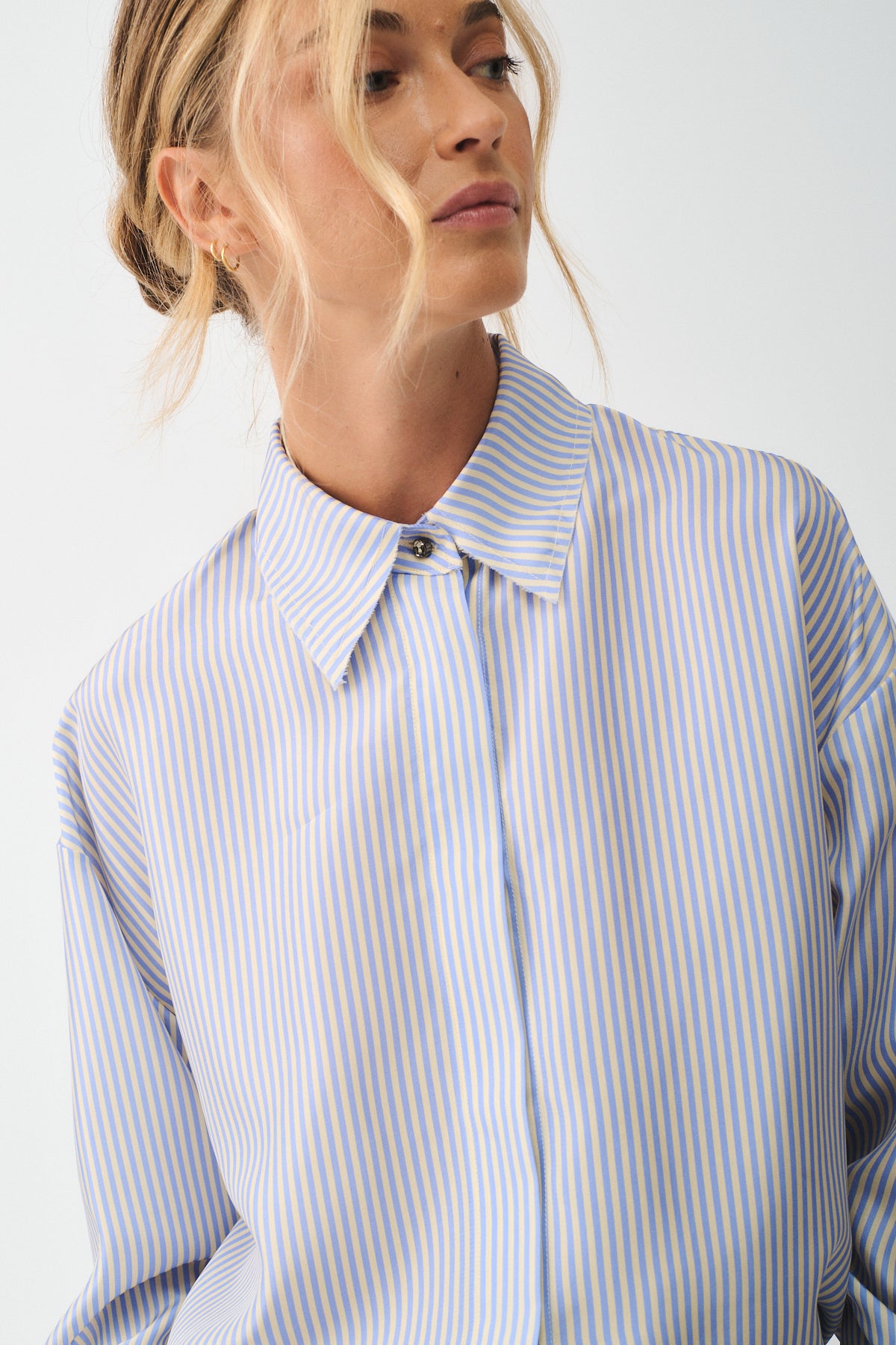 CAMICIA ISOTTA IN SETA CON BOTTONI GIOIELLO indossata da modello con colletto e righe blu e gialle.