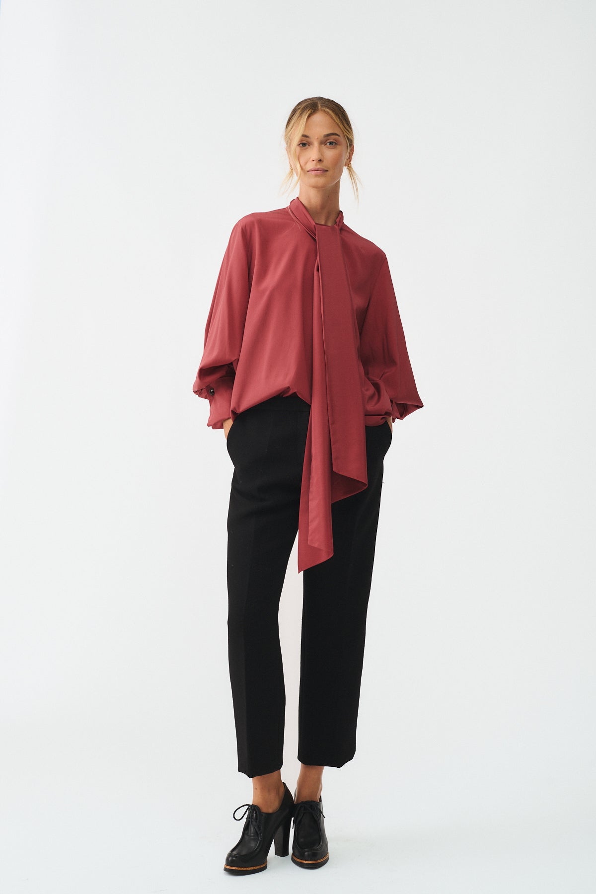 CAMICIA CHARLOTTE IN SETA CON SCIARPA indossata da una donna elegante con pantaloni neri e scarpe basse.