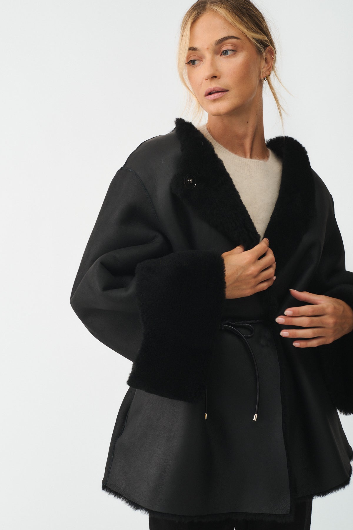 Reversible upcycled shearling coat with V-neck and regular fit, featuring a sophisticated black design.