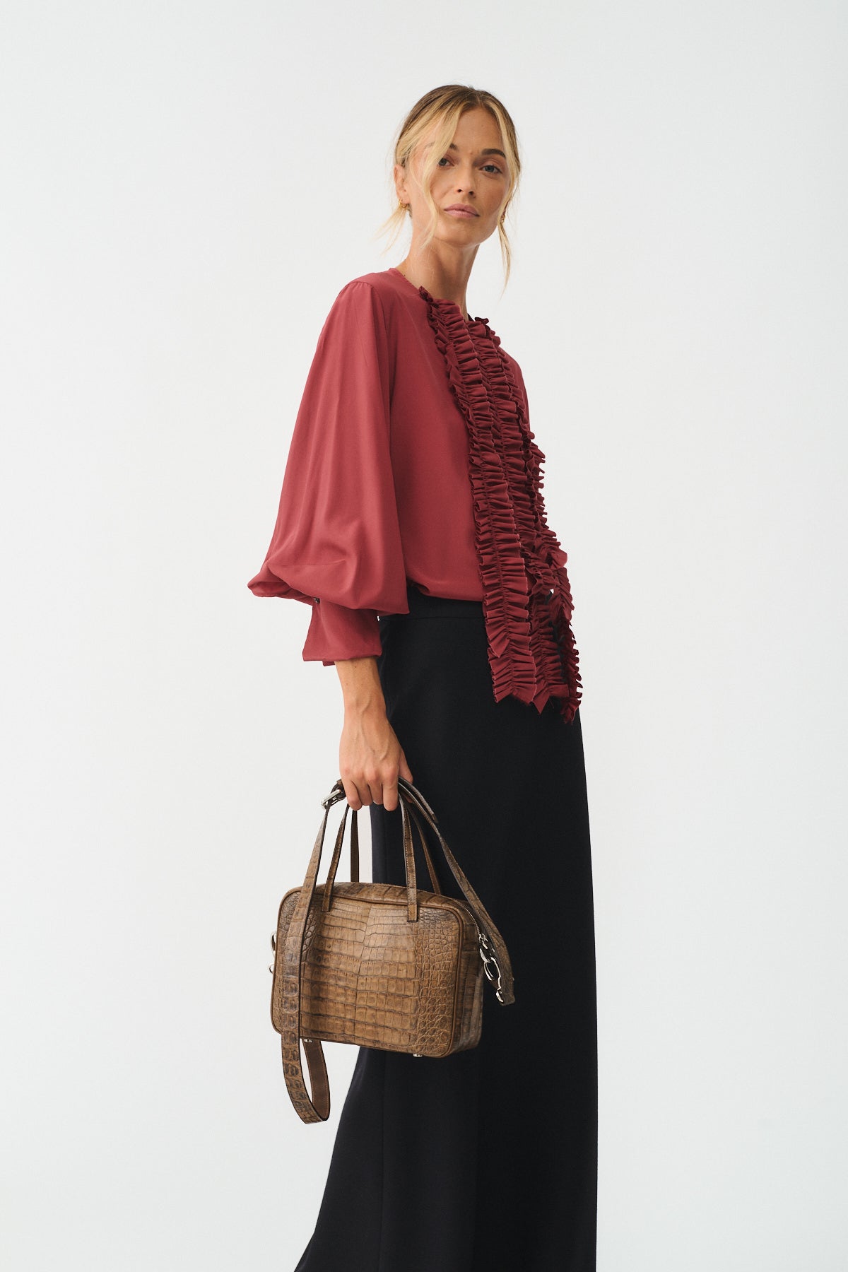 CAMICIA CHARLOTTE IN SETA CON ROUCHES E POLSI CON GEMELLI indossata da una modella con borsa di design.