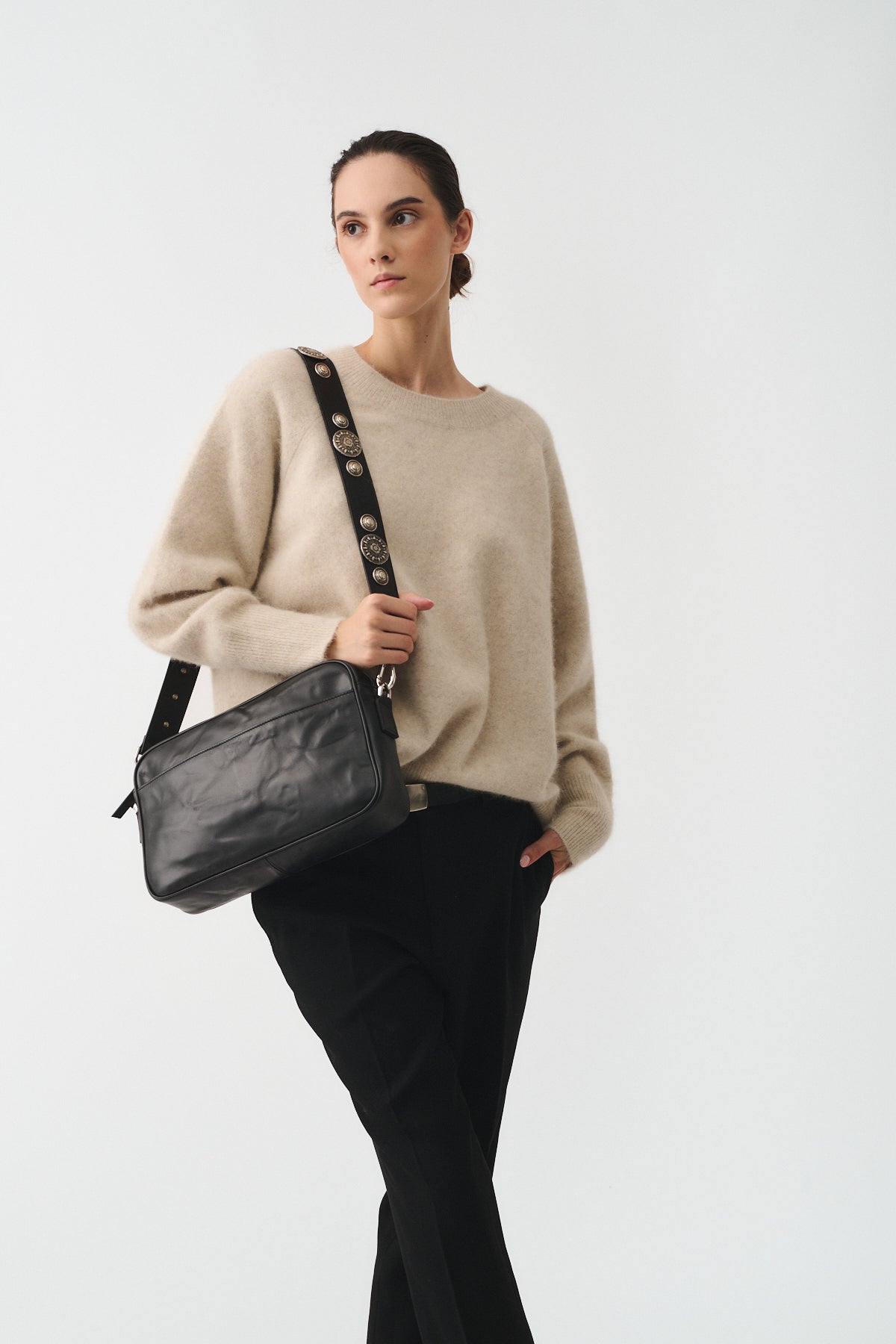 Model showcasing the MAFALDONA VITELLO LAVATO ROCK bag with an adjustable strap in a stylish casual outfit.