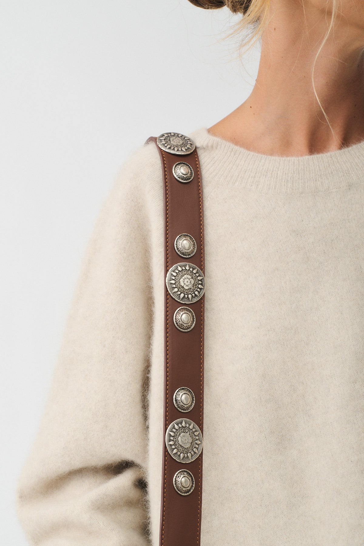 MAFALDA VITELLO LAVATO ROCK close-up of stylish strap with decorative silver studs on a soft sweater.