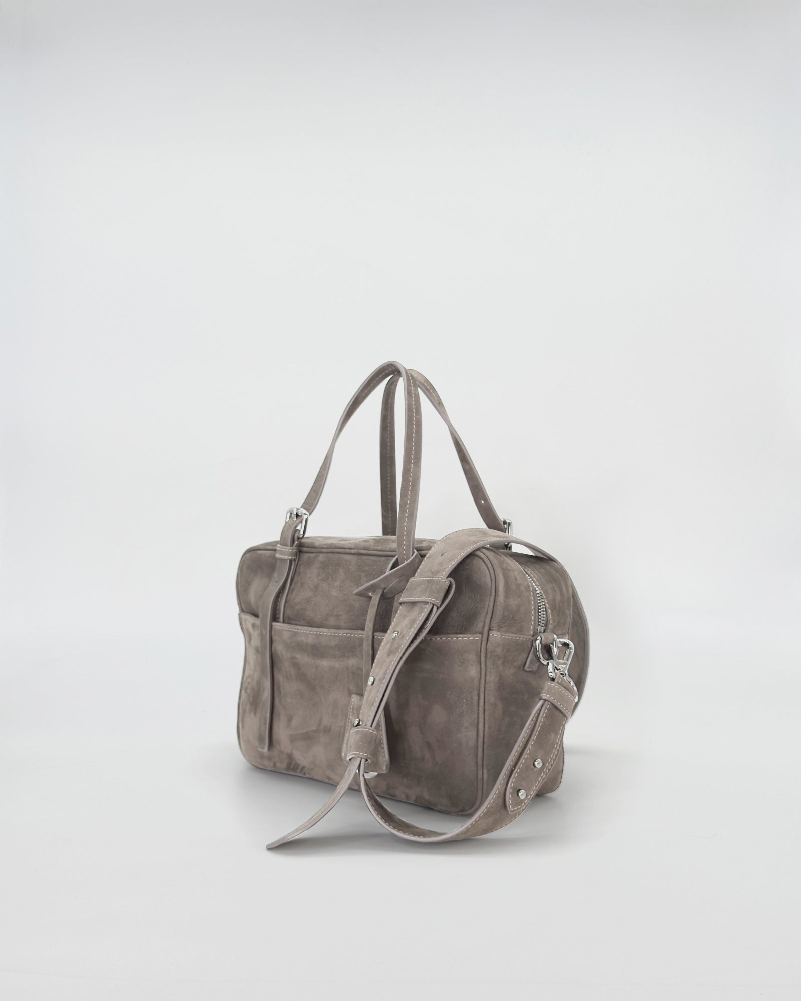 Frida Small Nabuk bag in soft grey nubuck leather, showcasing a modern sporty design with elegant retro charm.