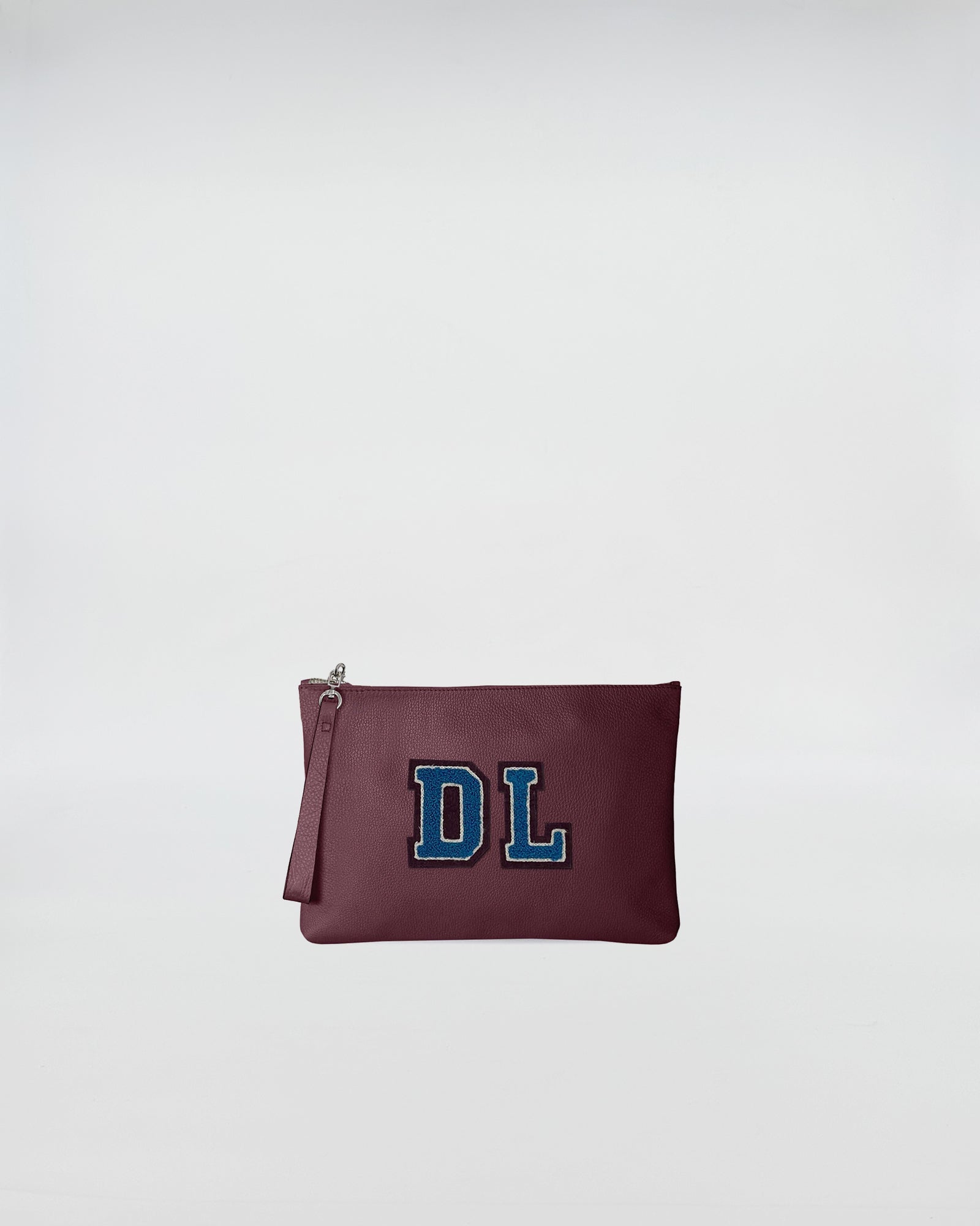 POCHETTE JOY PERSONALIZZATA con patch personalizzato DL, in pelle vinaccia, chiusura con zip, design pratico.