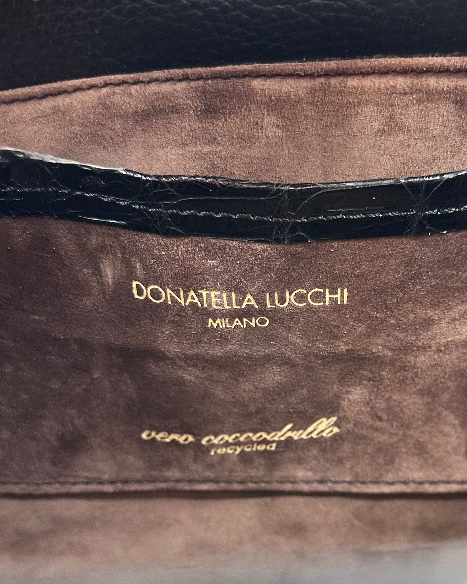 Interior label of a luxury bag by Donatella Lucchi with recycled crocodile leather details.