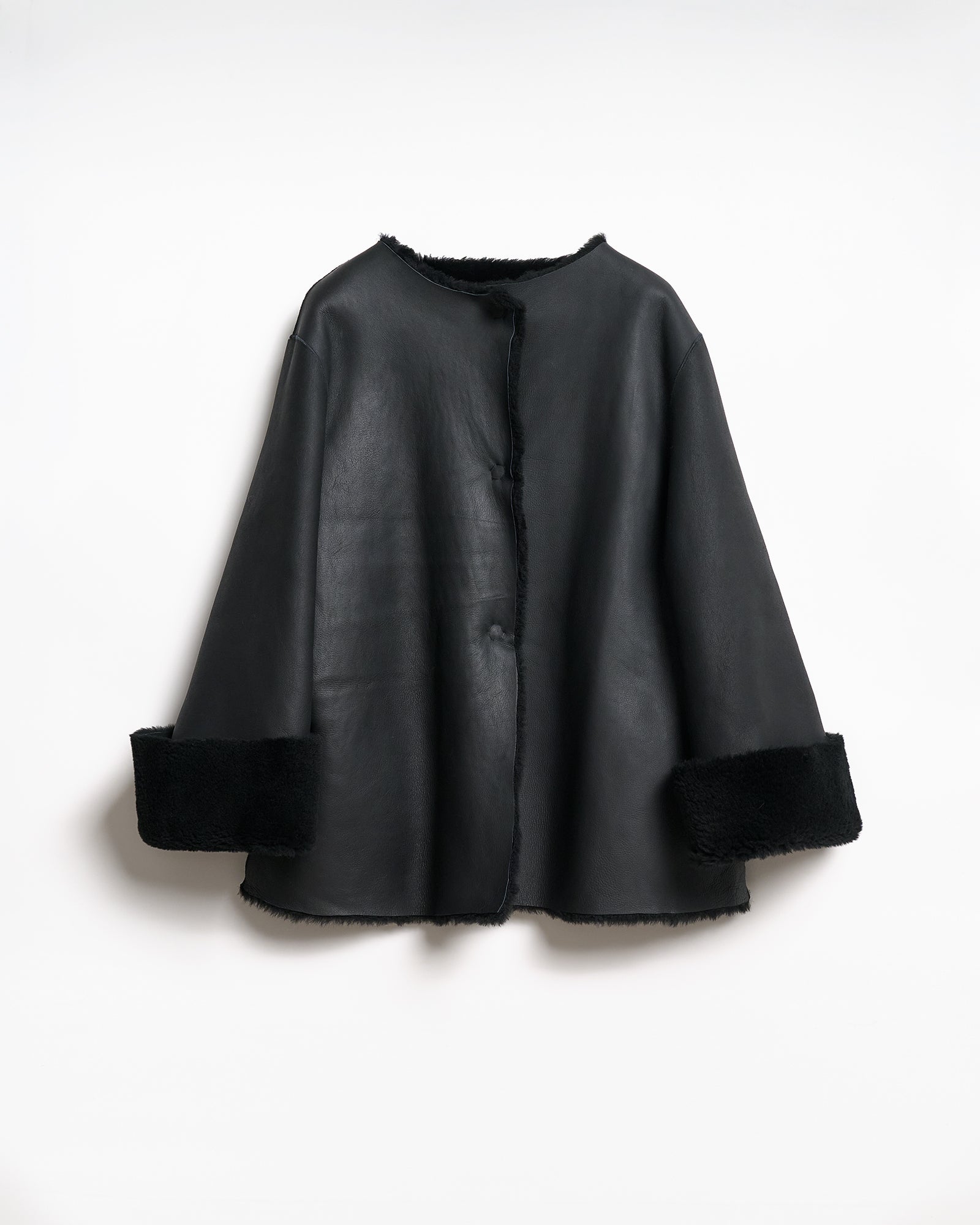 Reversible shearling coat featuring a relaxed fit and V-neck sleeves, showcasing elegance and softness.