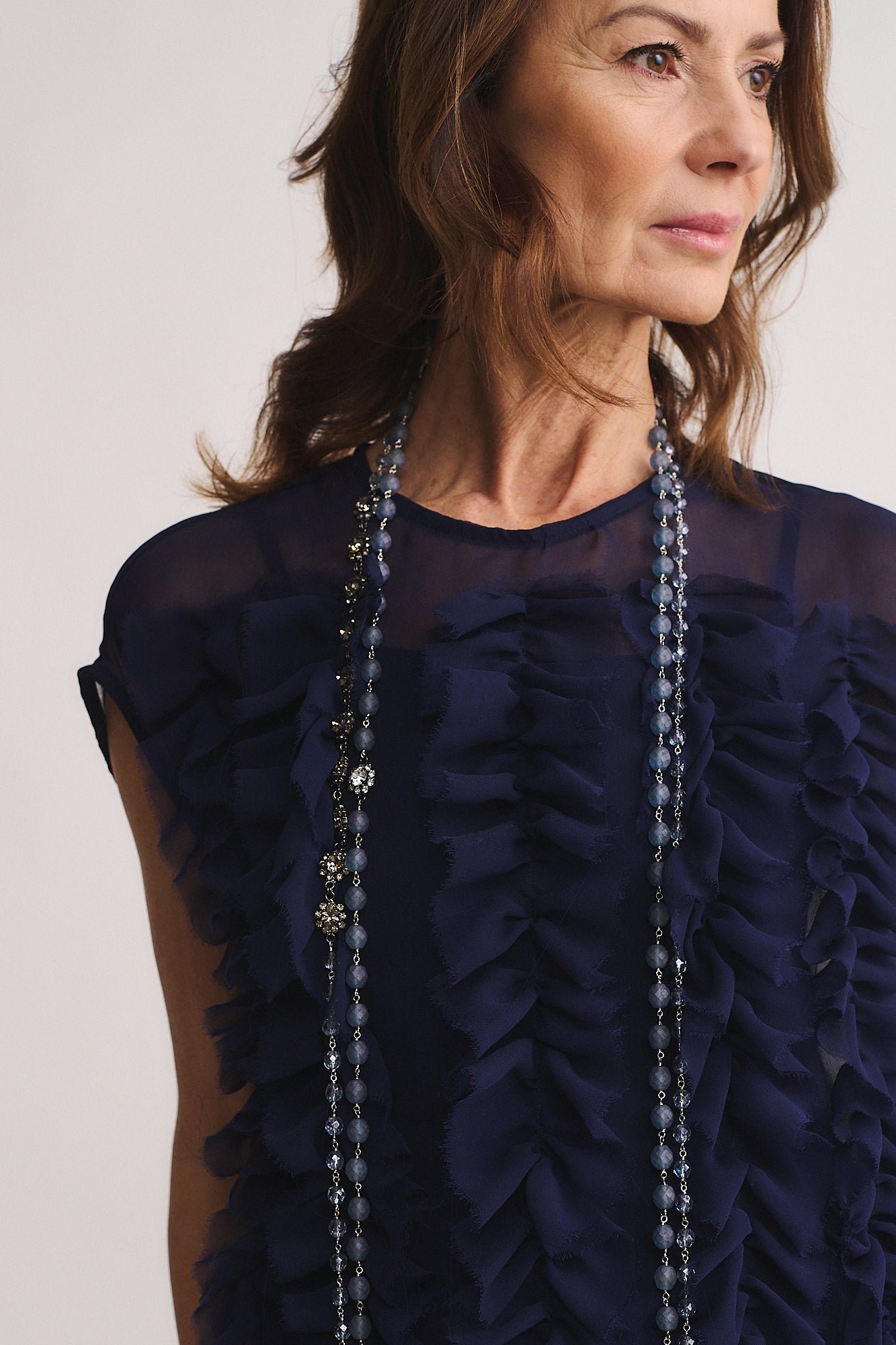 Collana Mod. 41 indossata da una donna su una maglia blu scuro, evidenziando le perle di mezzo cristallo e il design elegante.