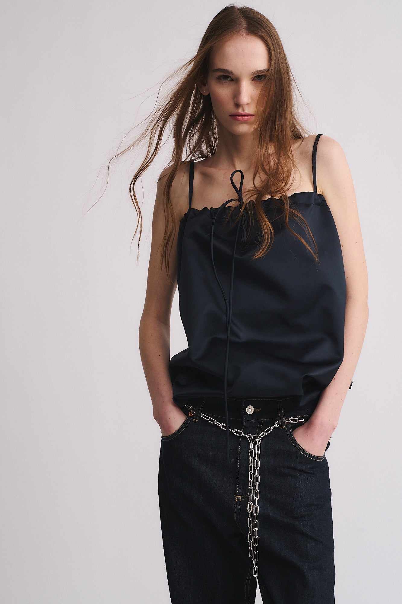 Model wearing a stylish dark top with a focus on a CINTURA IN CATENA accessory for a vintage look.