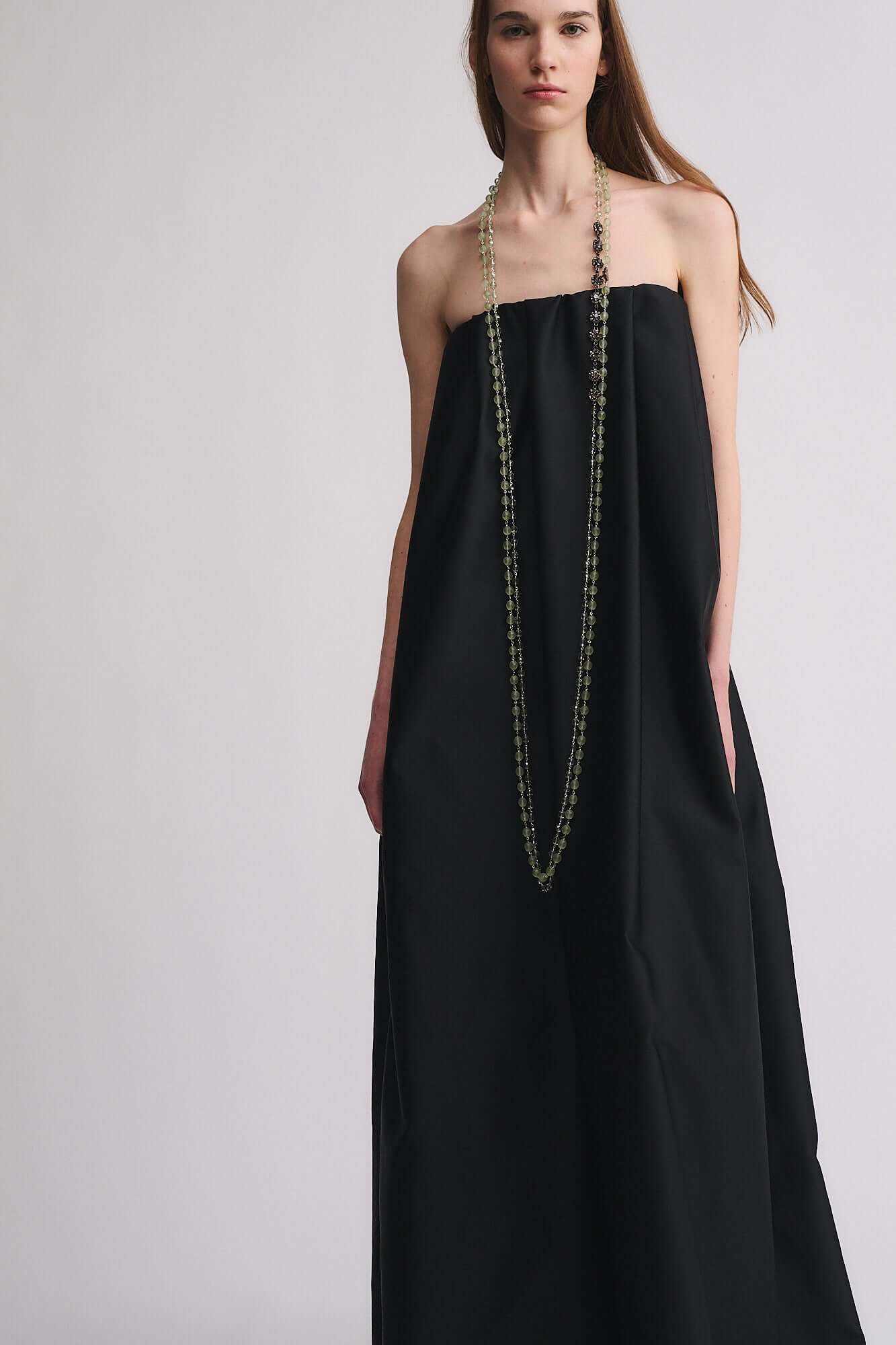 Collana mod. 47 indossata da donna in abito nero, con eleganti perle e strass color cristallo.