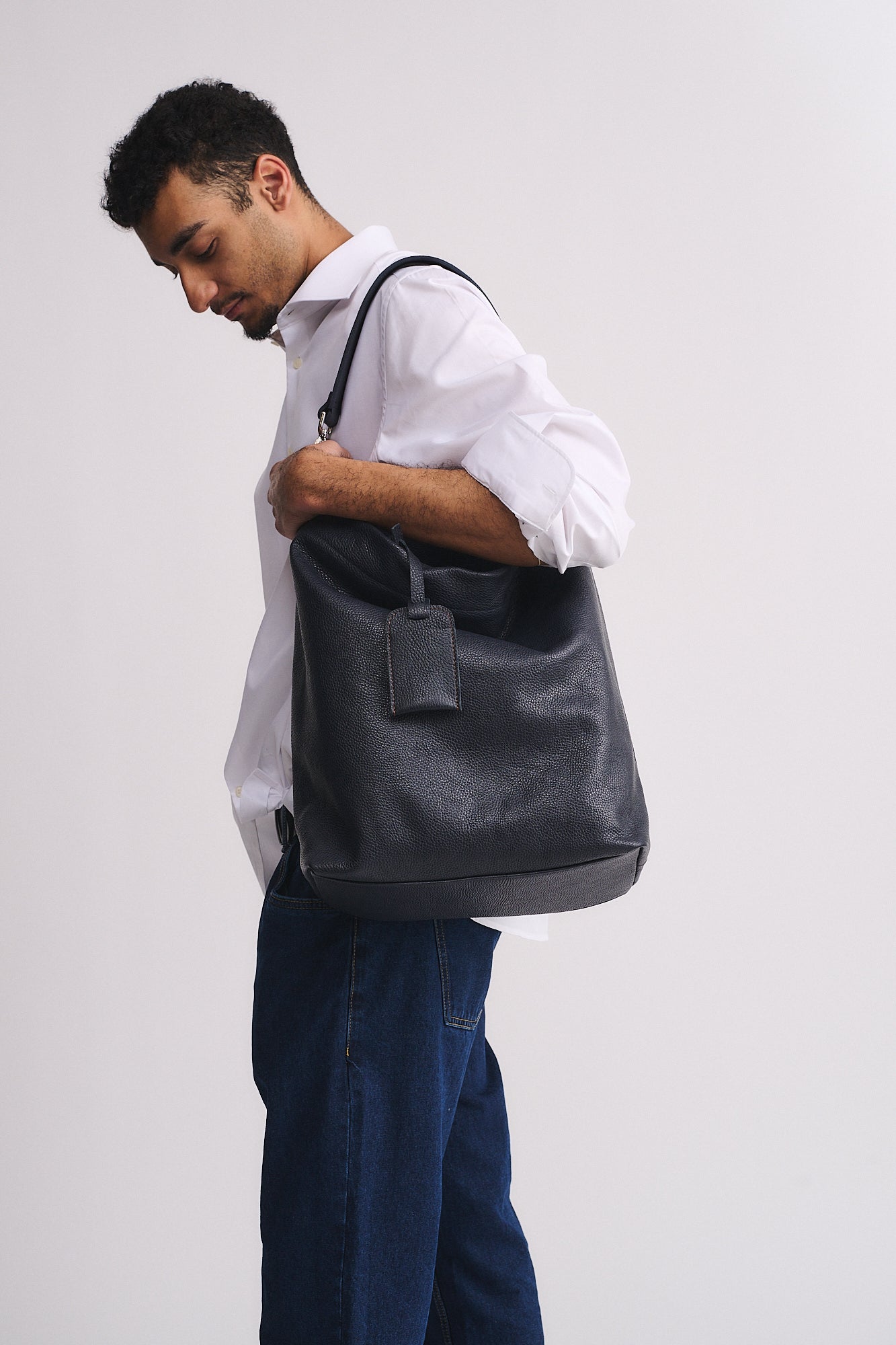 Uomo che indossa una borsa in pelle nera FORD PERSONALIZZATA, elegante e funzionale.