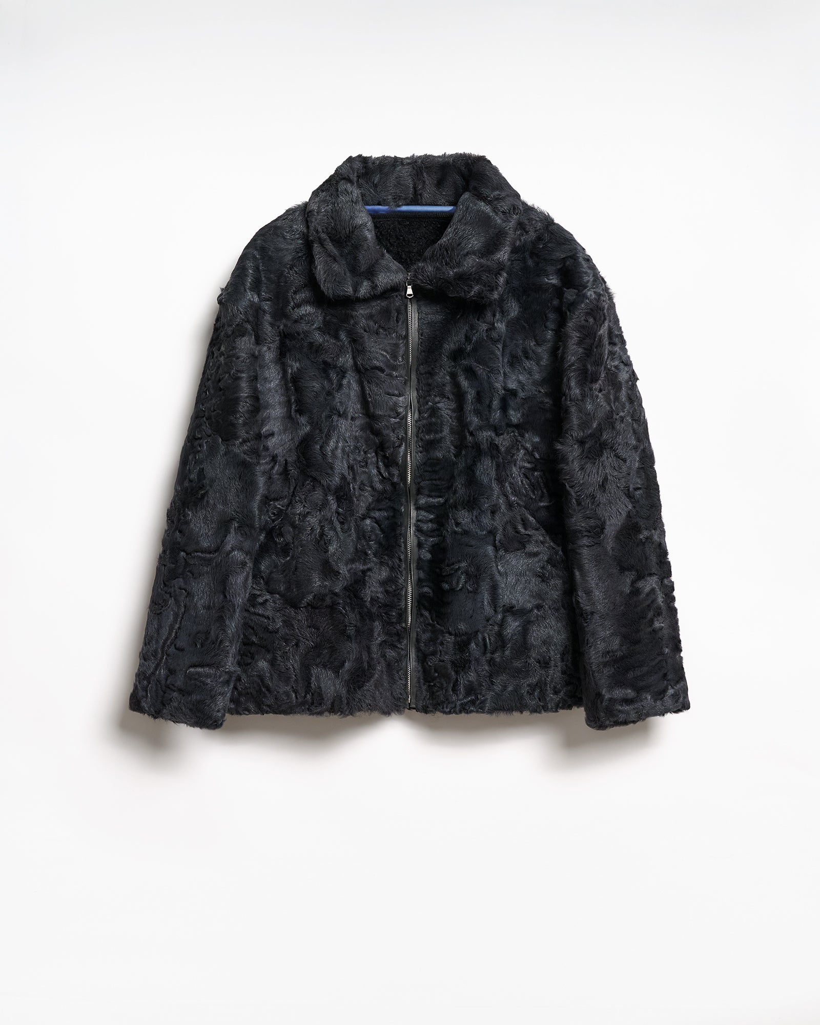 Black upcycled blouson jacket with textured fabric and zip front, featuring a contemporary silhouette and stylish details.