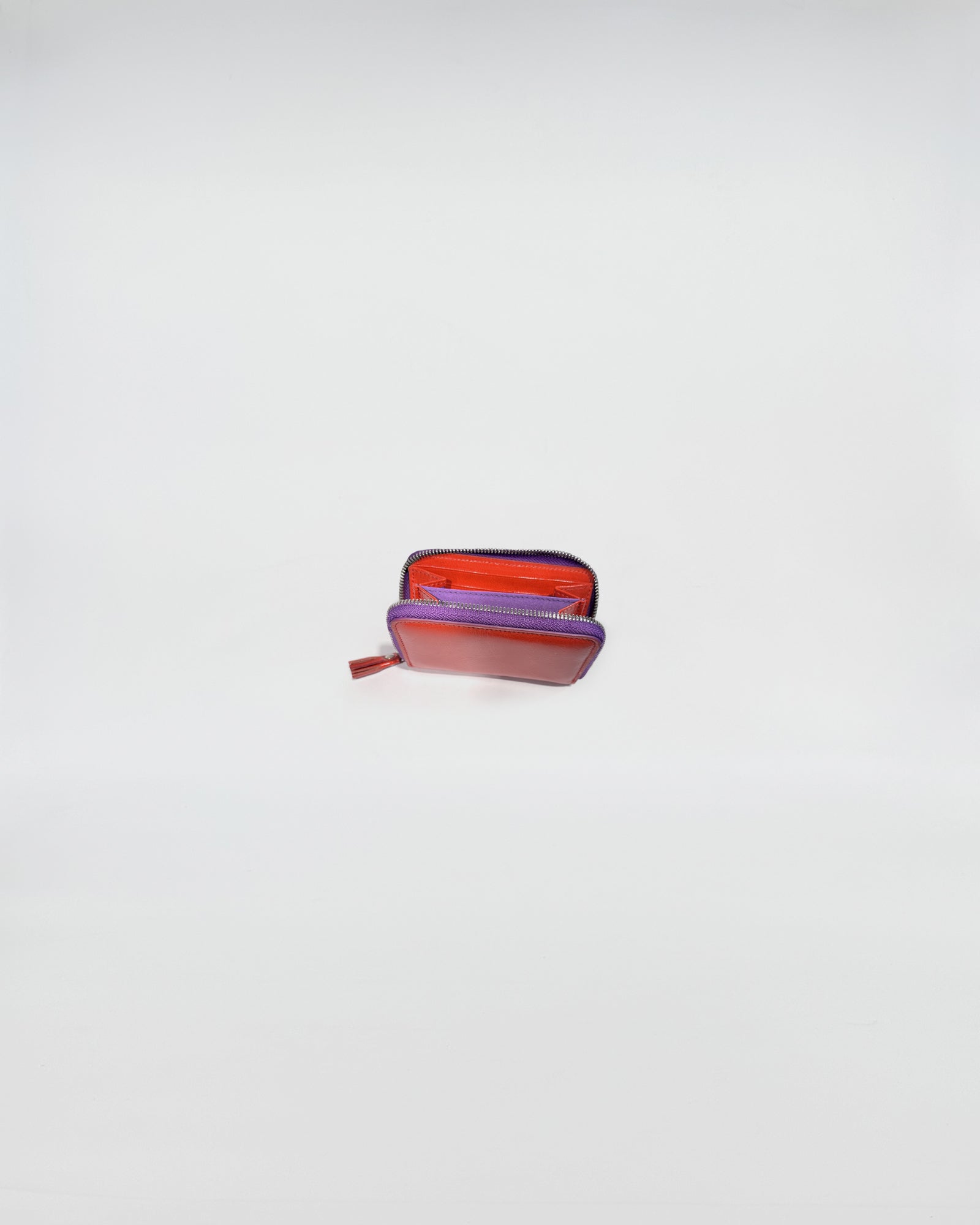 Portafoglio Zip Mini in vitello con chiusura a zip viola, interni ben organizzati per carte e contanti.