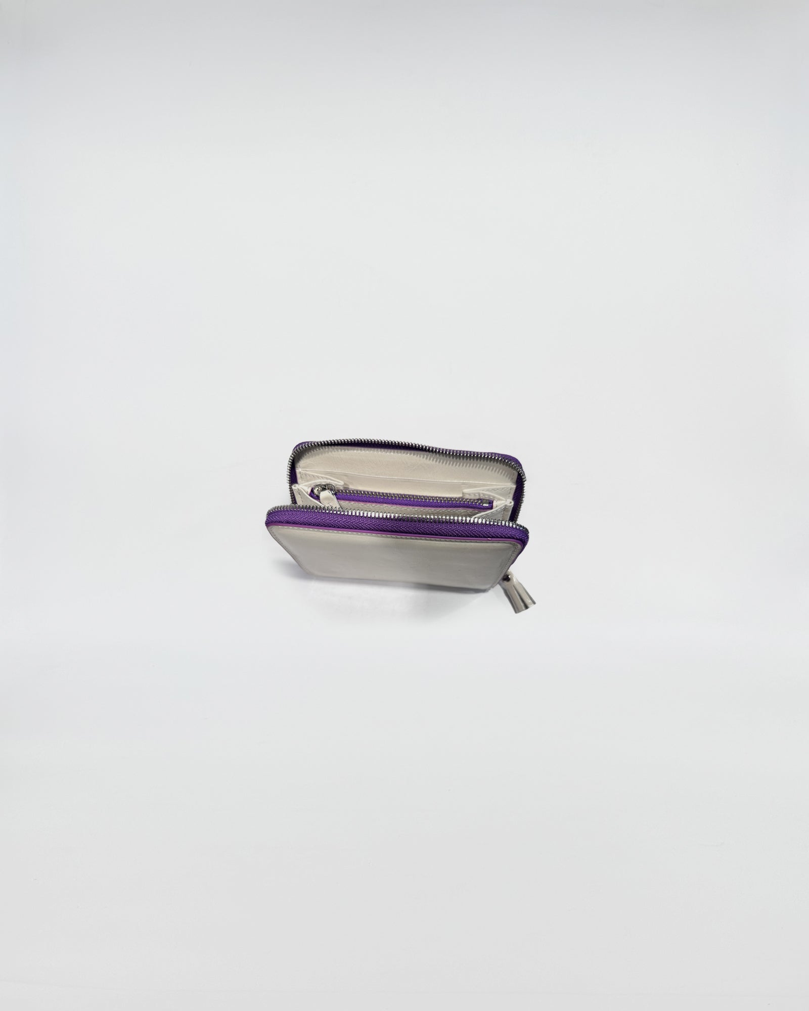 Portafoglio Zip Small con chiusura a zip viola, interni in pelle e scomparti per carte e contanti.