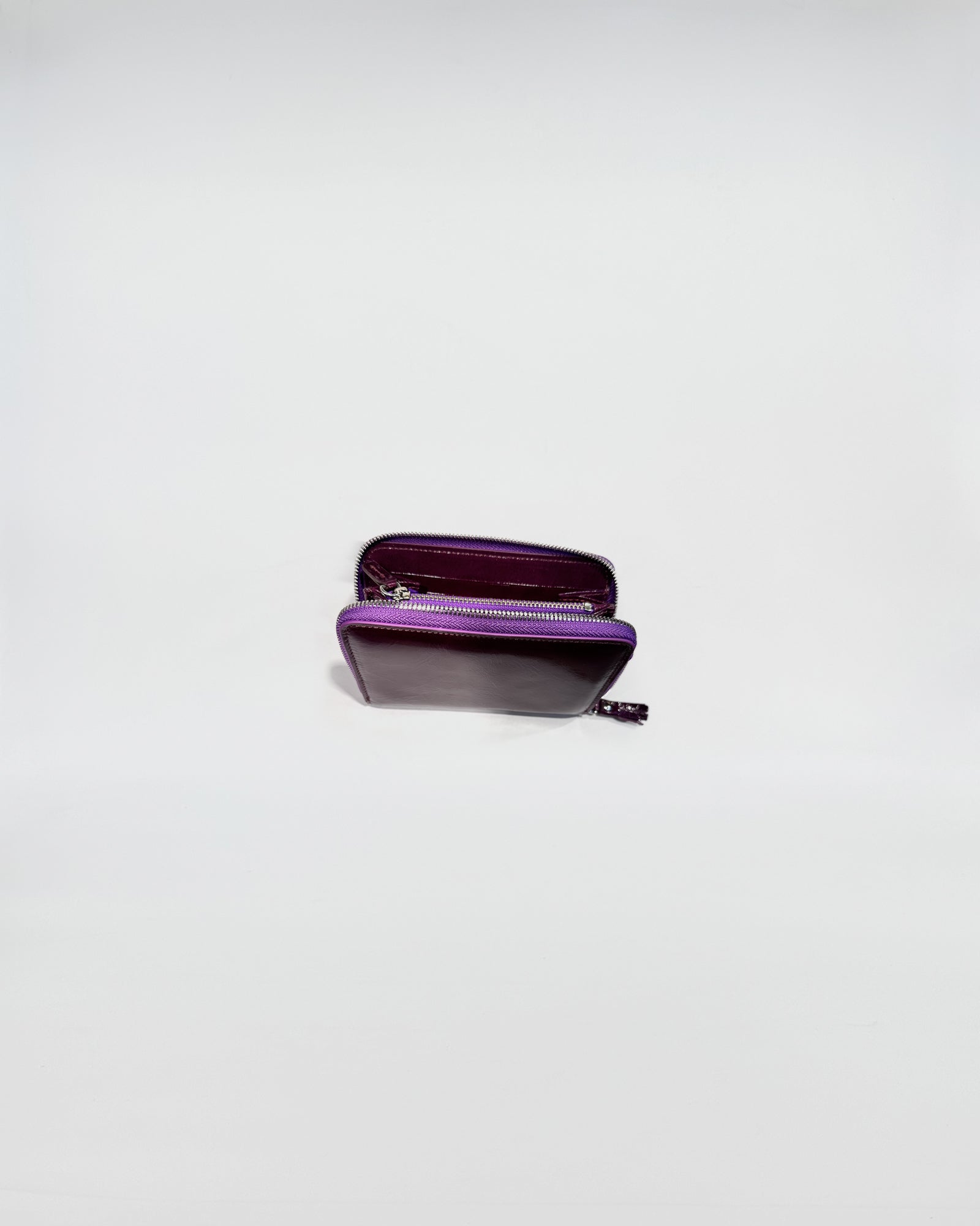 Portafoglio Zip Small in vitello con chiusura zip viola e interni viola, elegante e pratico per uso quotidiano.