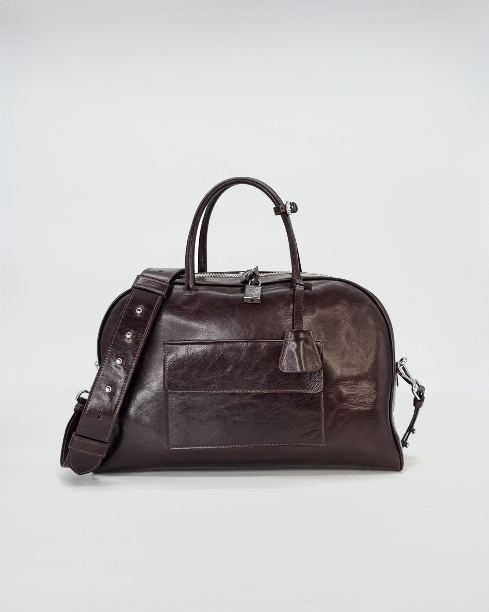 Elegant dark brown medium handbag with stylish curves and a detachable strap.
