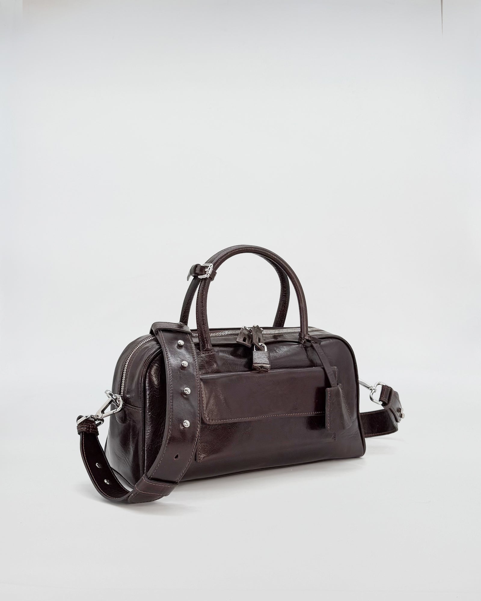 Small dark brown vitello semilucido handbag with a sleek design and shoulder strap.