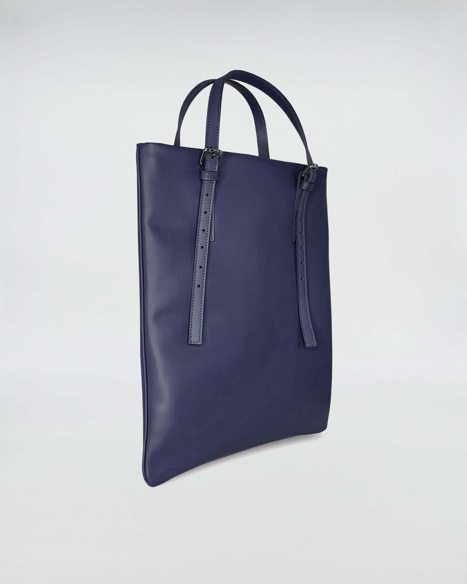 Elegant AMELIE PORTACOMPUTER in navy blue leather with versatile straps for carrying.