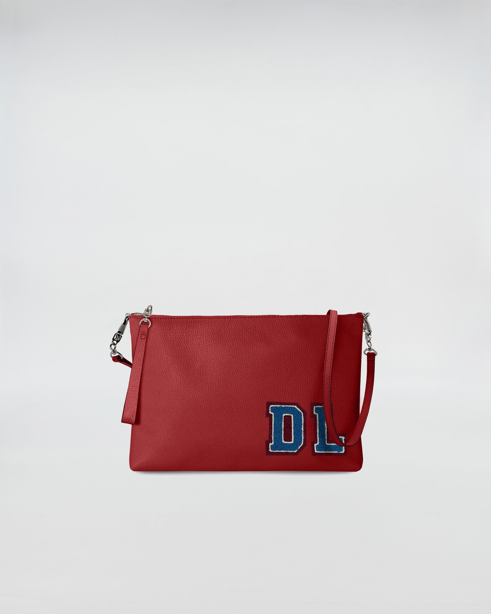 BUSTA A4 PERSONALIZZATA CON TRL in red leather with removable strap and blue patch detail.