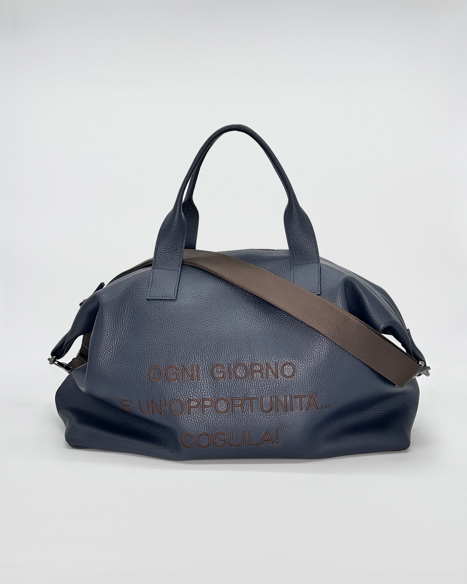 Navy travel bag with handles and adjustable strap, featuring motivational text on the side.