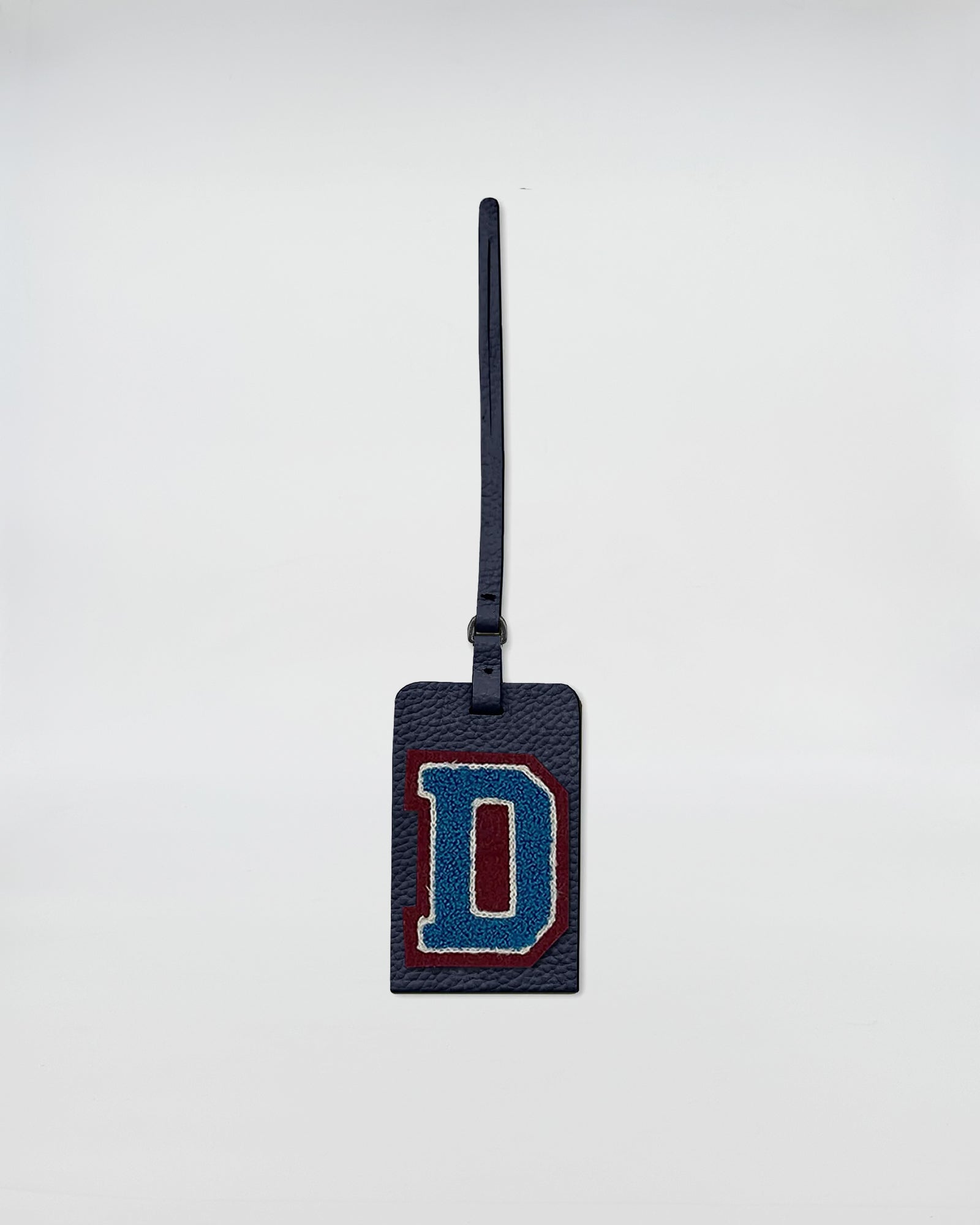 Charm personalizzato patch in pelle rettangolare con lettera D ricamata in blu e rosso.