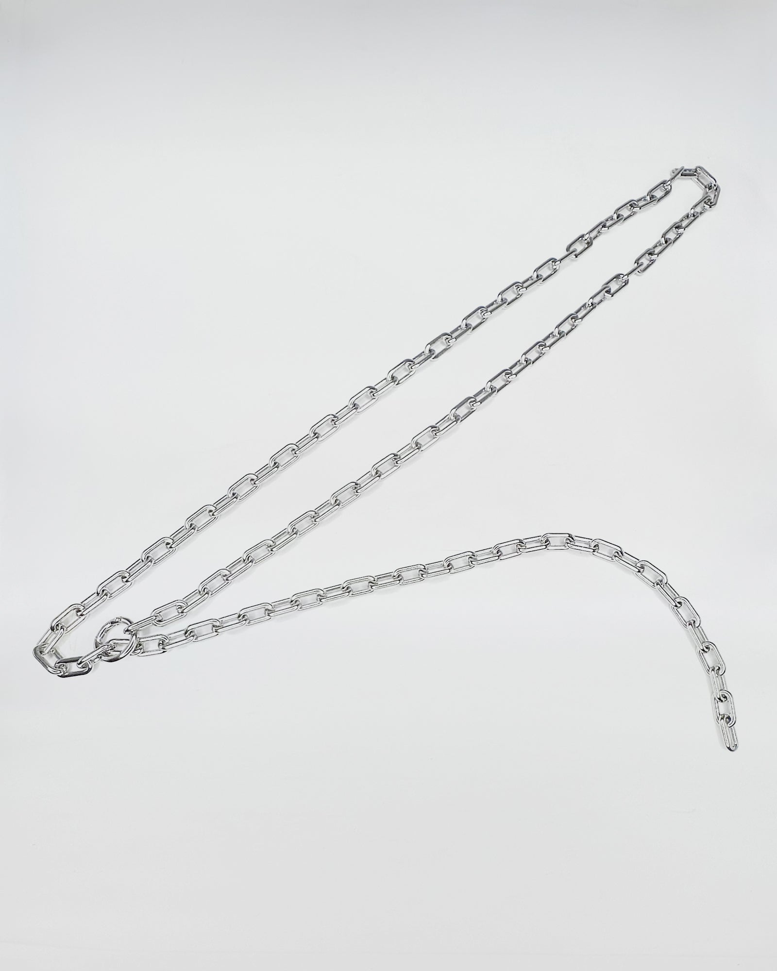 CINTURA IN CATENA in metallo argentato, un accessorio audace con un design vintage e ribelle.