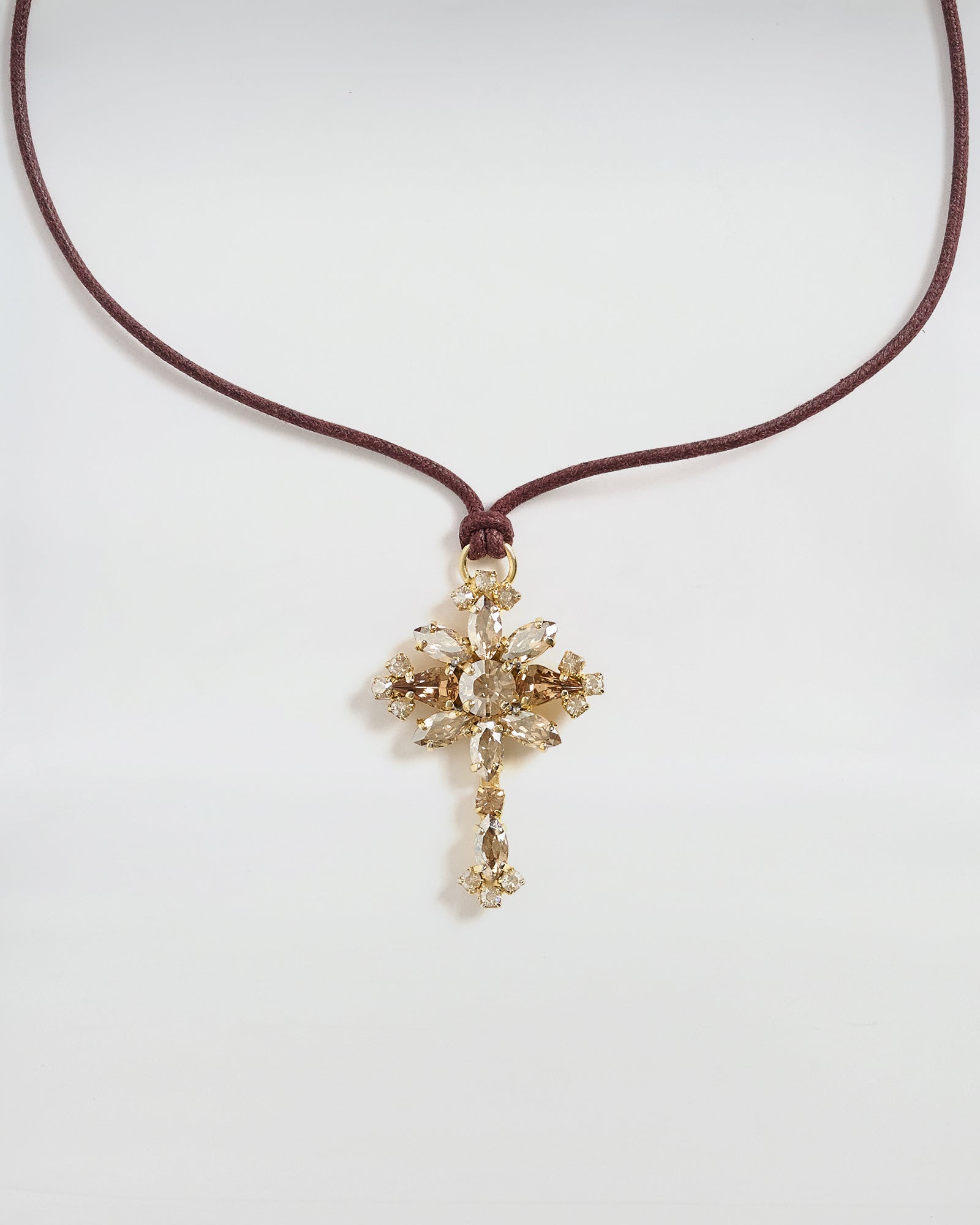 Collana Dori con ciondolo a croce in cristallo e nastro color cuoio, design elegante e sofisticato.
