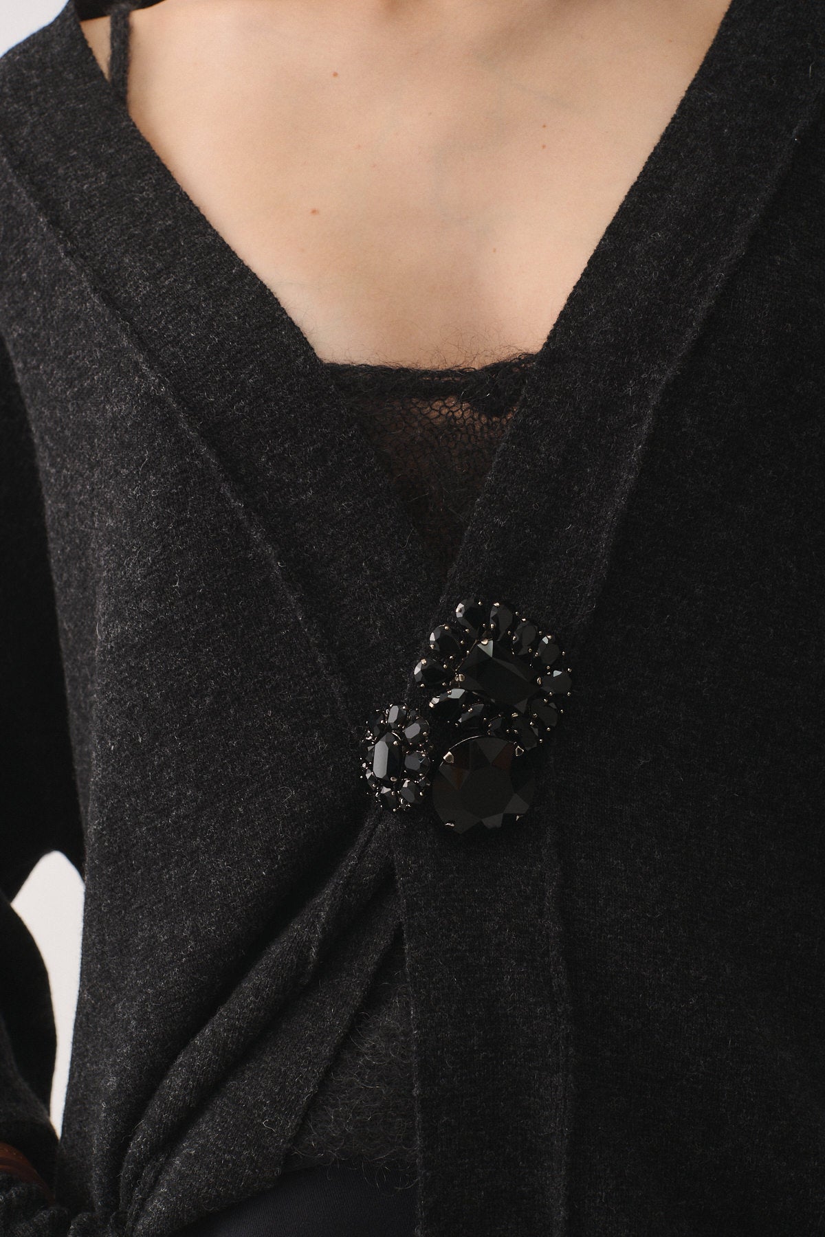 SPILLA MAXI black stone brooch on a dark cardigan for a modern and elegant look.
