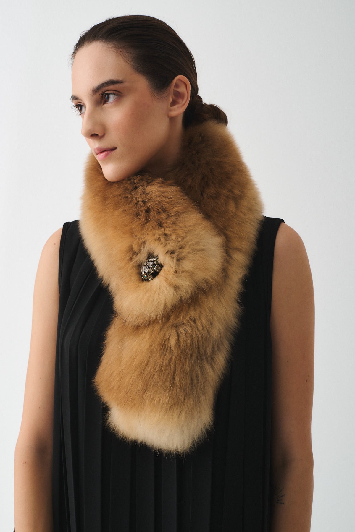 Elegant upcycled fox fur stole worn as a versatile accessory, featuring a decorative brooch for added flair.
