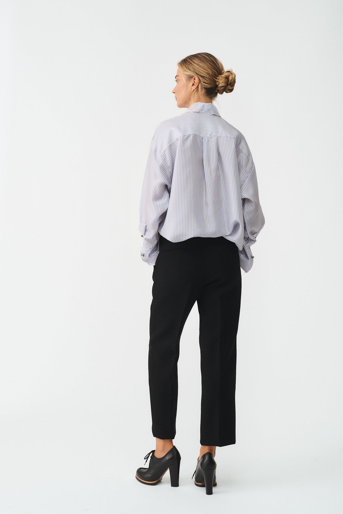 CAMICIA ISOTTA IN SETA CON BOTTONI GIOIELLO vista posteriore su modello con pantaloni neri.