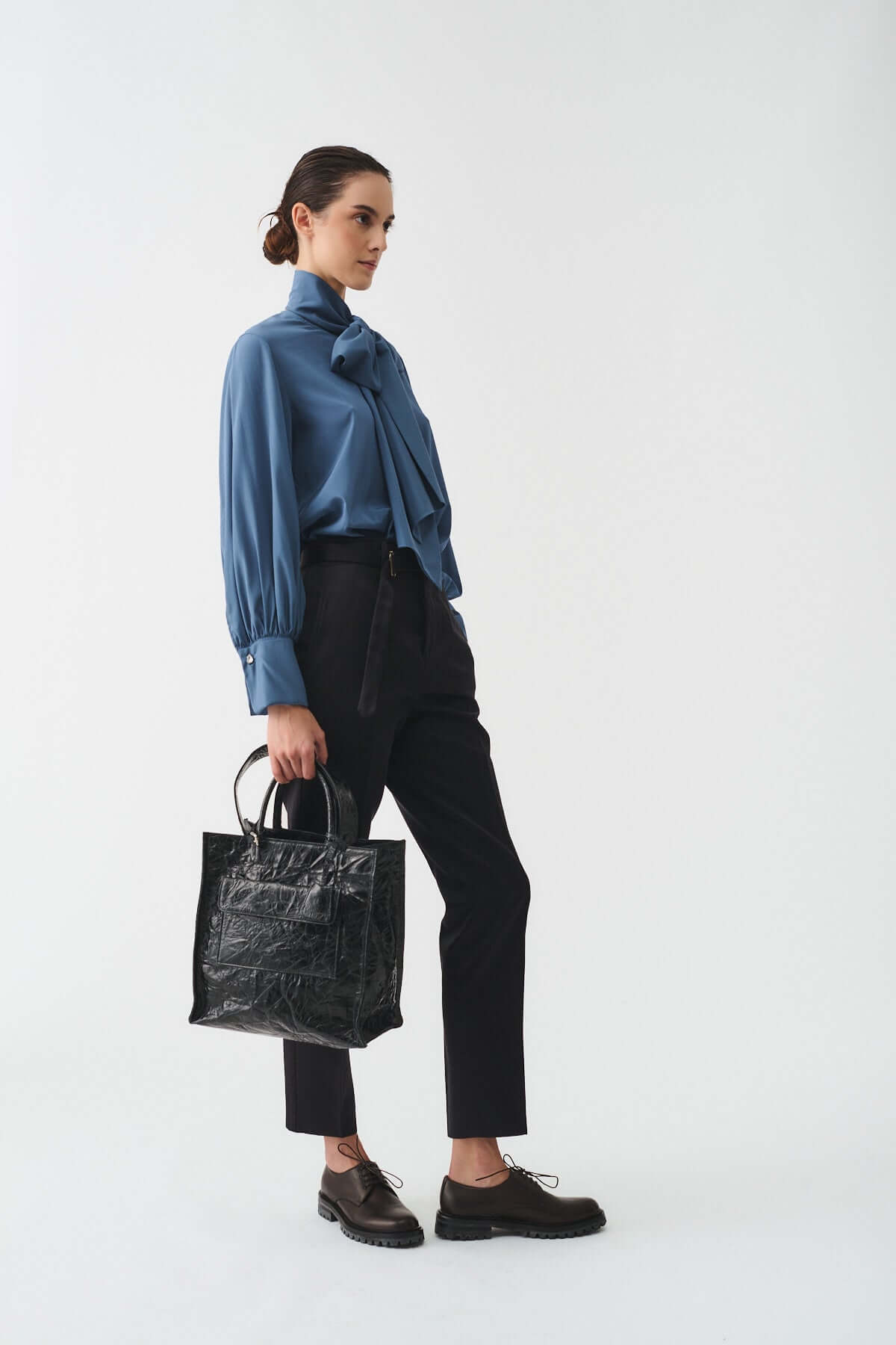 Model showcasing the LUDOVICA VITELLO STRIZZATO shopping bag with stylish outfit.