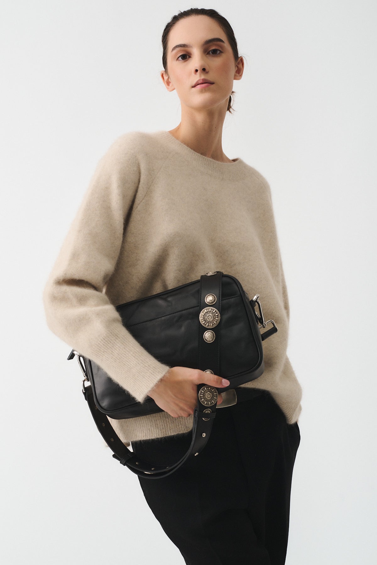 Model showcasing MAFALDONA VITELLO LAVATO ROCK handbag with a removable strap and stylish embellishments.