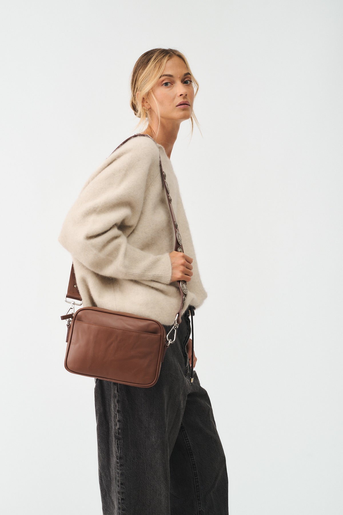 MAFALDA VITELLO LAVATO ROCK - donna con borsa marrone, indossata con maglione chiaro, stile casual.