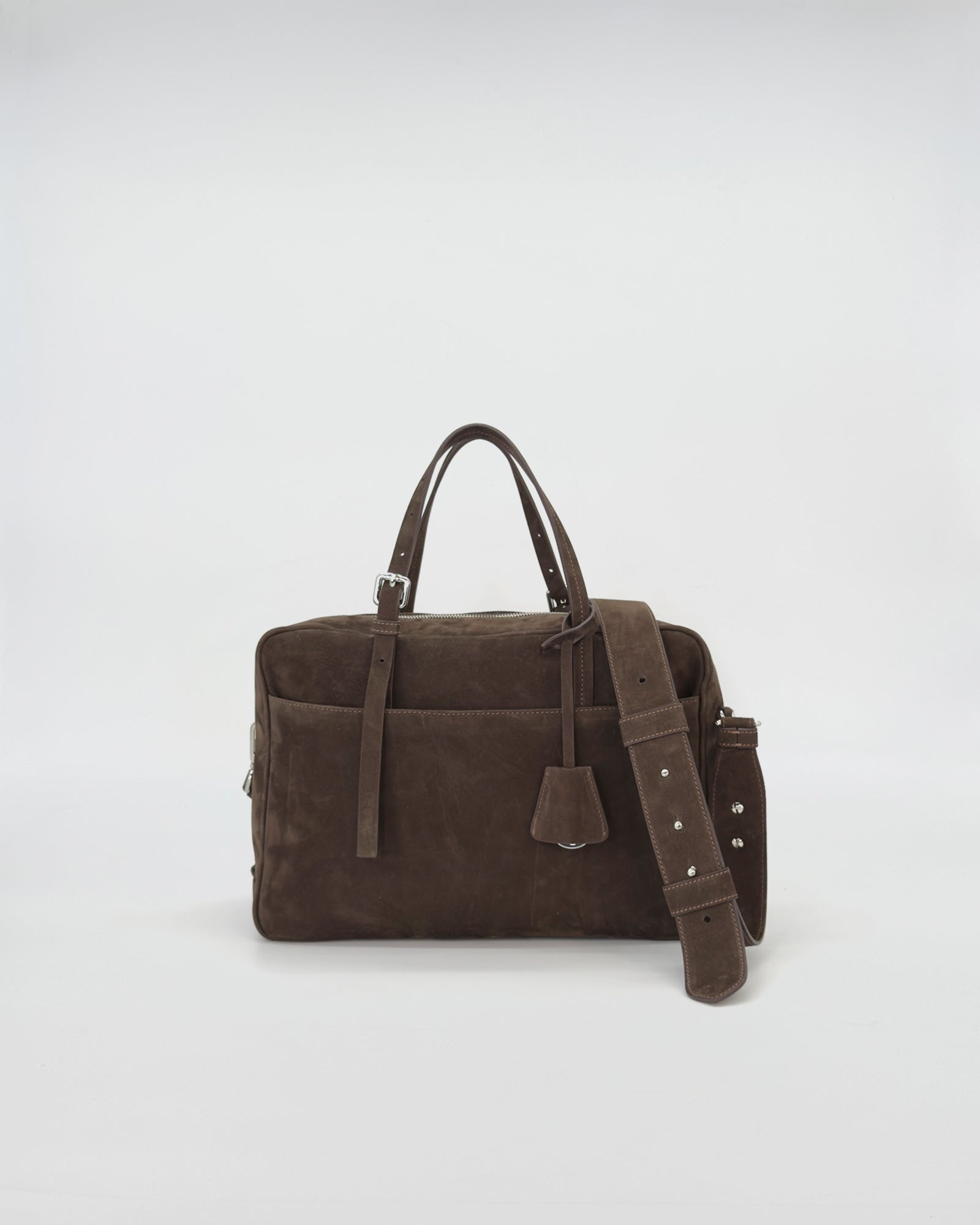 Elegant brown nabuk handbag with handles and adjustable strap, embodying a modern retro style.