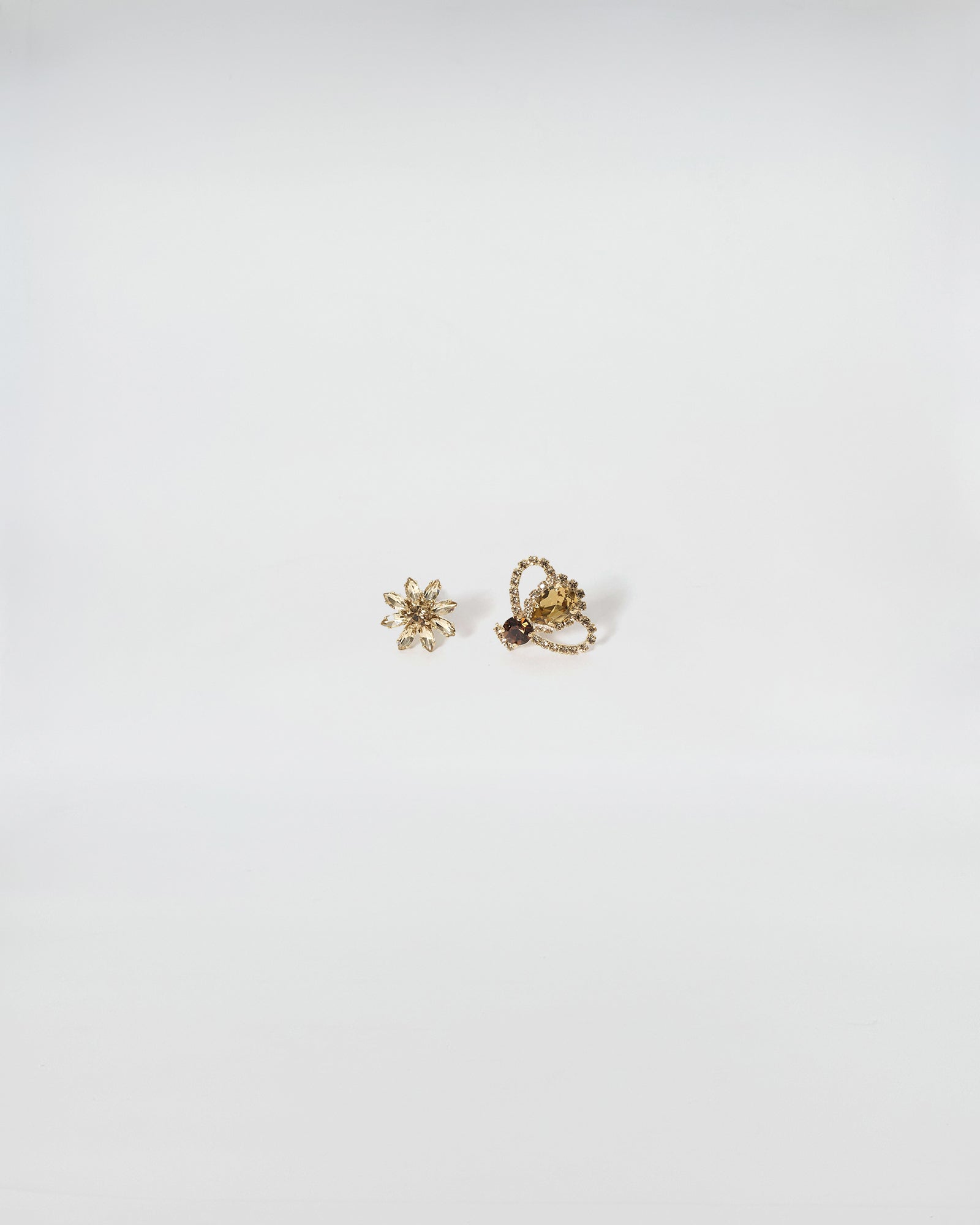 GEMELLI FIORE+APE REGINA, elegant cufflinks made of brilliant crystals with a gold finish, presenting a classic jewelry design.