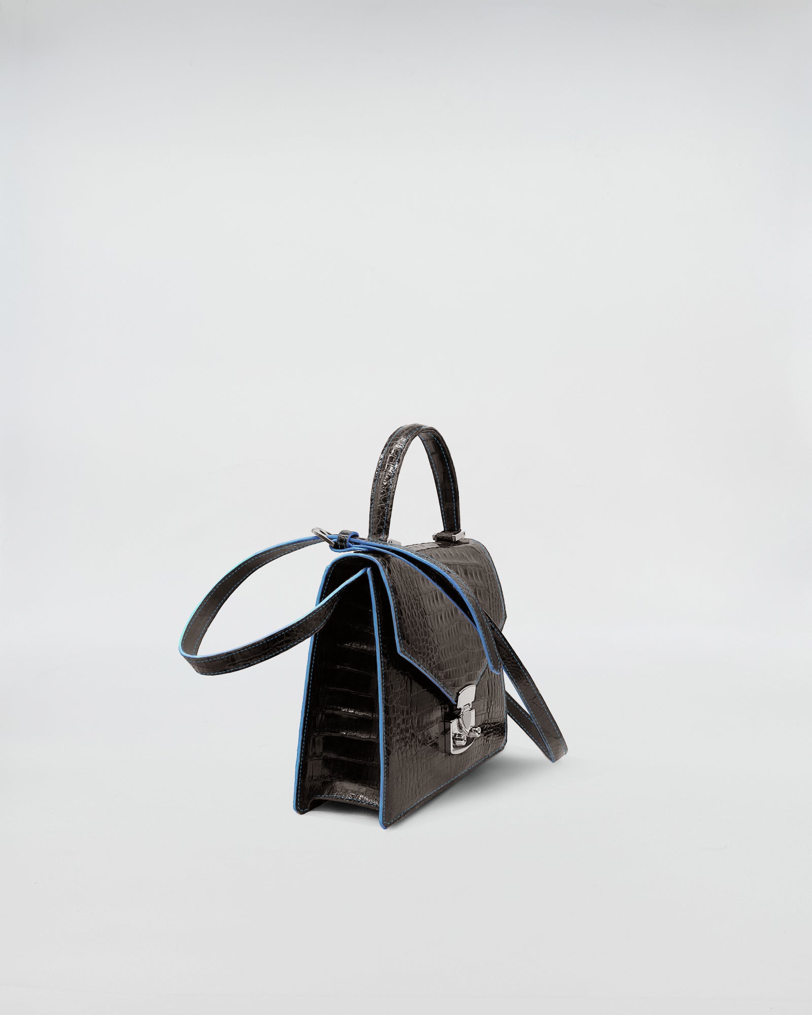 LADY D - COCCO RECYCLE bag made of recycled crocodile leather with green suede interior and blue edges.