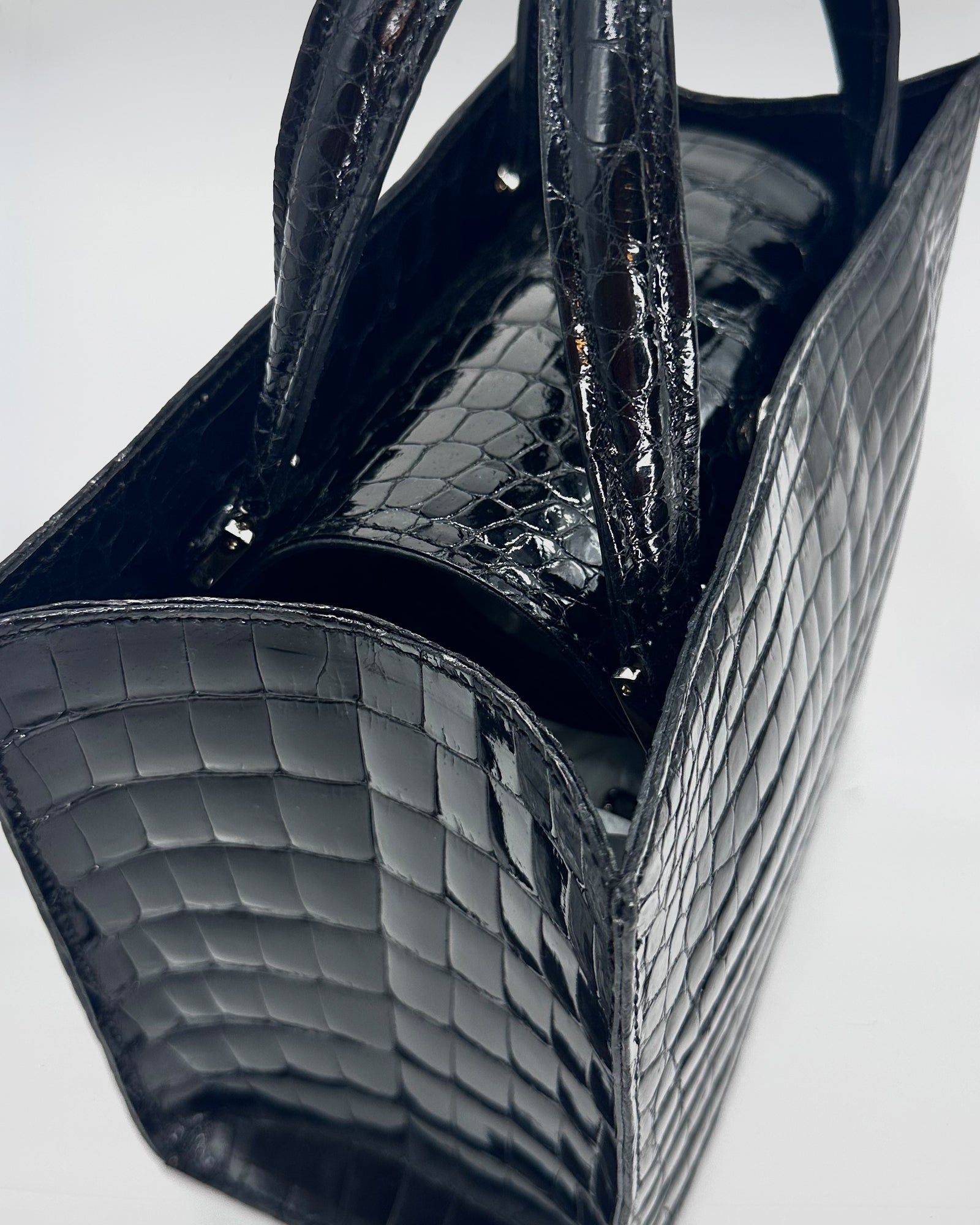 Matilda XS Cocco Recycle handbag in black recycled crocodile leather with elegant handles and soft suede interior.