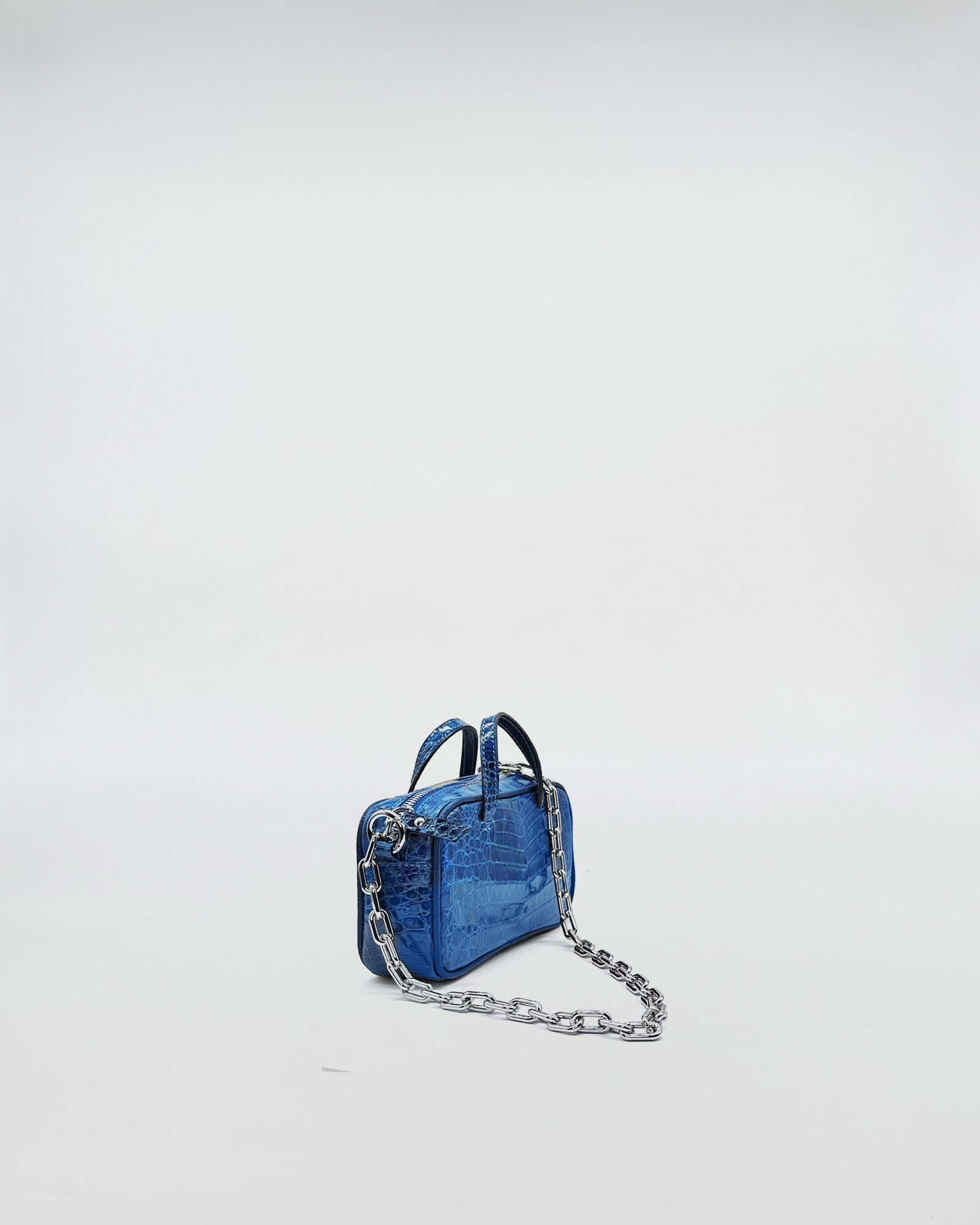 MICRO BAG NINA COLORATA MEDIUM COCCO RECYCLE in blue with metallic chain strap on a light background.