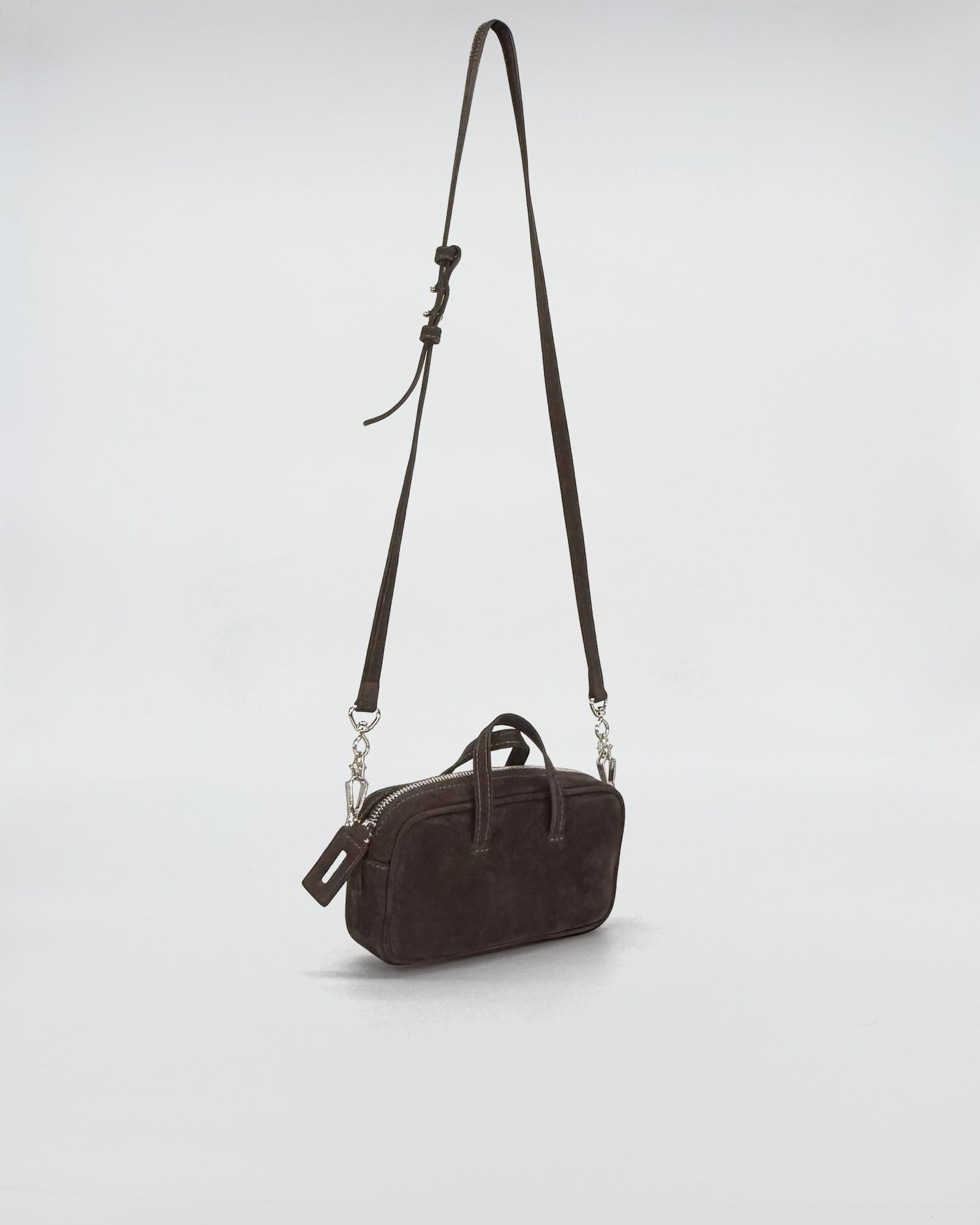 Compact dark nabuk micro bag with metal chain handle and adjustable strap, stylish and elegant.