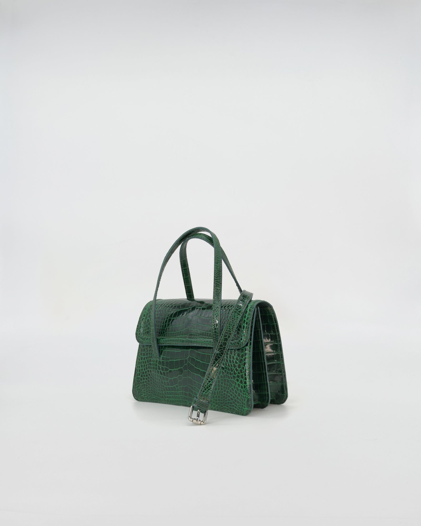 Elegant green crocodile pattern handbag with a shoulder strap, showcasing sustainable fashion.