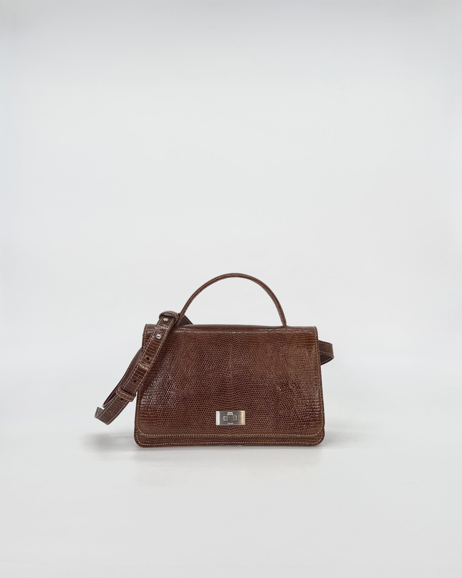 Elegant brown handbag in recycled tejus leather with metal closure and shoulder strap.